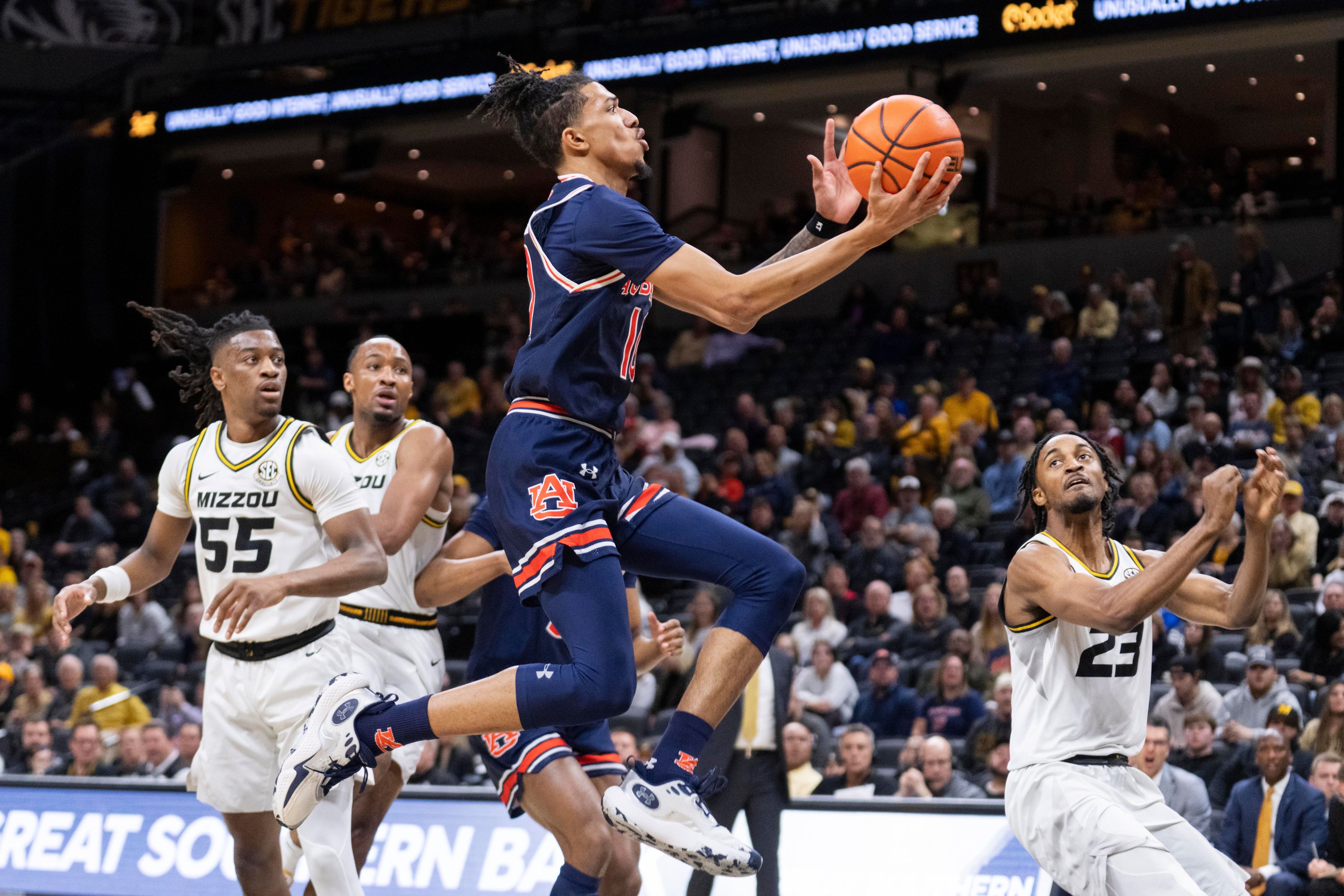 Auburn's Chad Baker-Mazara shoots against Missouri's Aidan Shaw, right, Sean East II, left, and Tamar Bates during the first half of an NCAA college basketball game Tuesday, March 5, 2024, in Columbia, Mo. (AP Photo/L.G. Patterson)