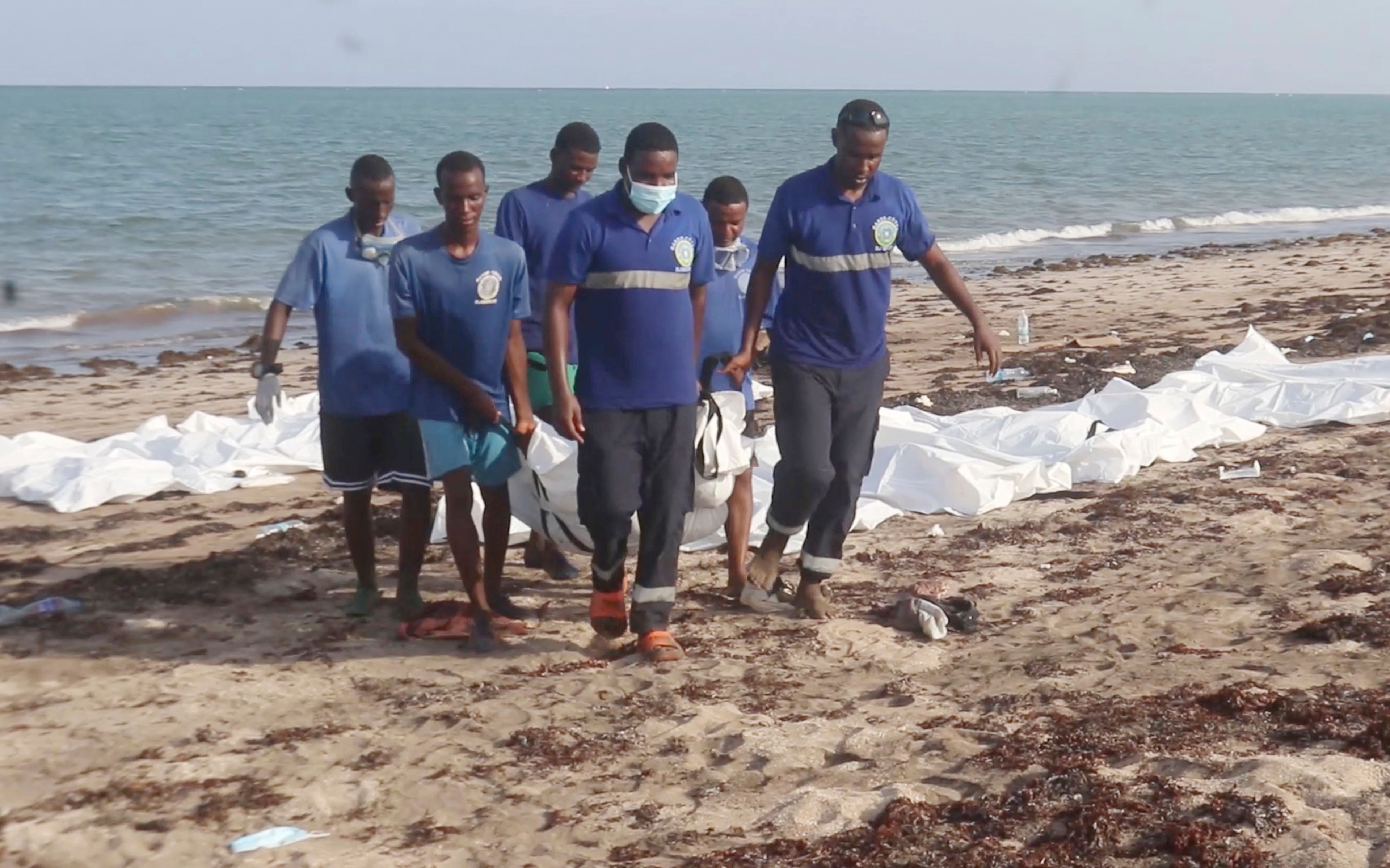 In this image made from video, Djiboutian coast guard workers load bodies of migrants who were washed away on the shore of the Red Sea, off the coast in Djibouti Wednesday, Oct. 2, 2024. (Djiboutian Coast Guard via AP)