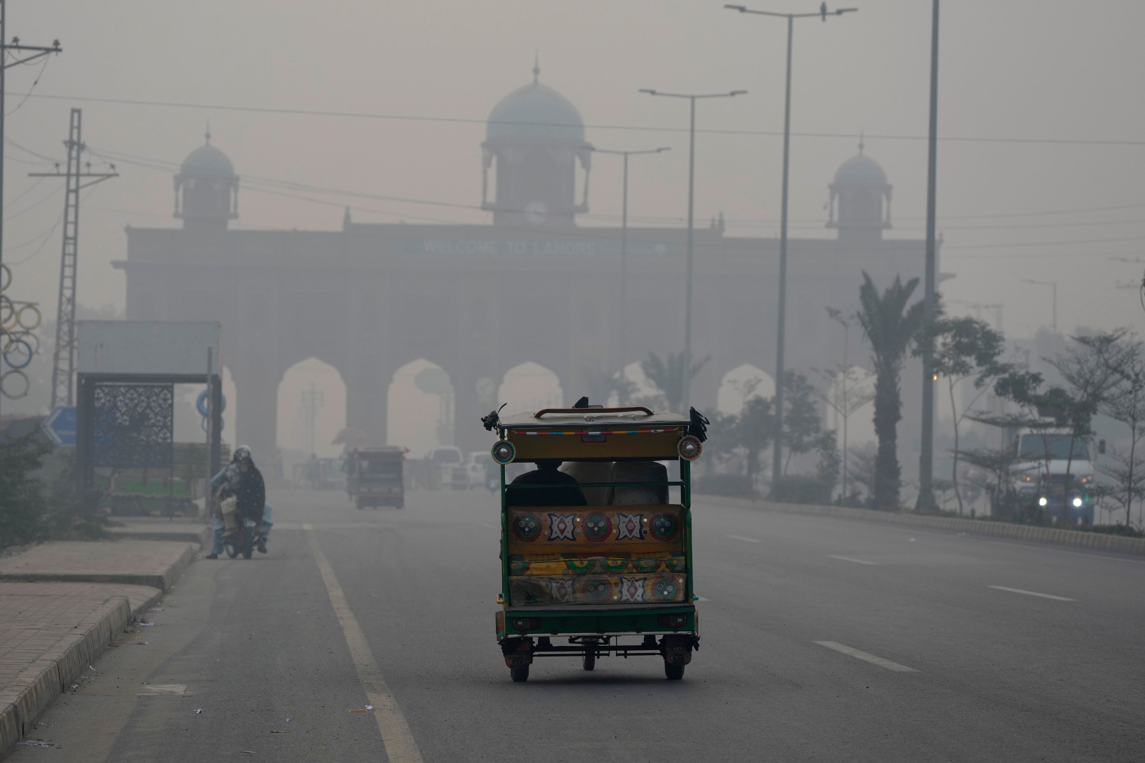 A motorcycle-rickshaw drives on a road as smog envelops the areas of Lahore, Pakistan, Wednesday, Nov. 6, 2024. (AP Photo/K.M. Chaudary)