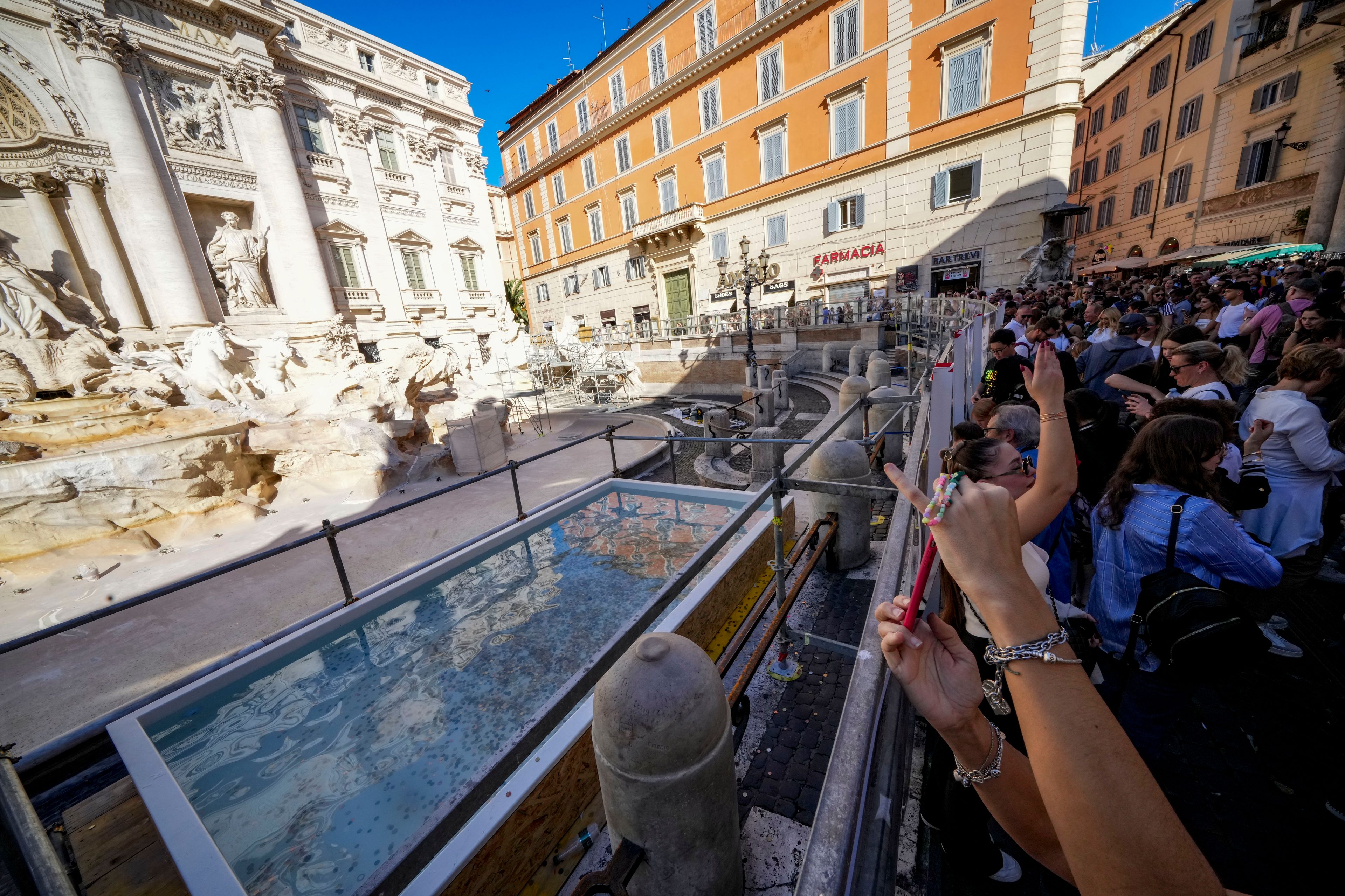 A small pool is seen in front of the Trevi Fountain to allow tourists to throw their coins in it, as the fountain has been emptied to undergo maintenance work that it is expected to be completed by the end of the year, in Rome, Friday, Nov. 1, 2024. (AP Photo/Andrew Medichini)