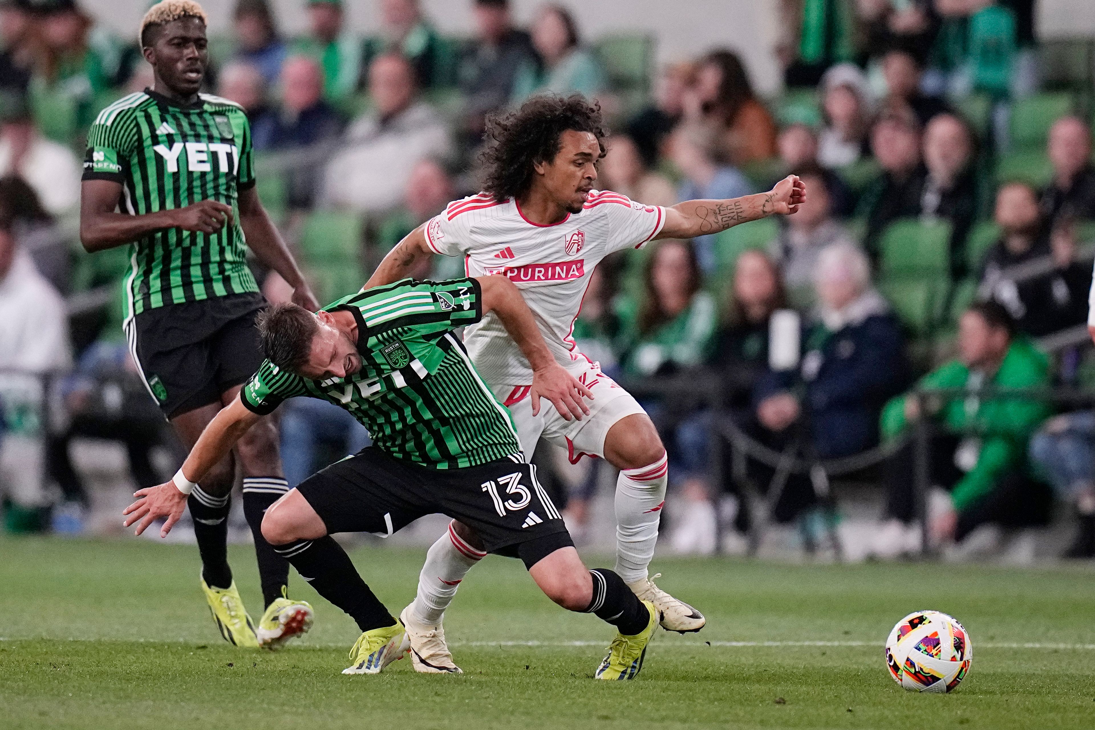 Austin FC midfielder Ethan Finlay (13) and St. Louis City midfielder Aziel Jackson, right, chase a pass during the second half of an MLS soccer match Saturday, March 9, 2024, in Austin, Texas. (AP Photo/Eric Gay)