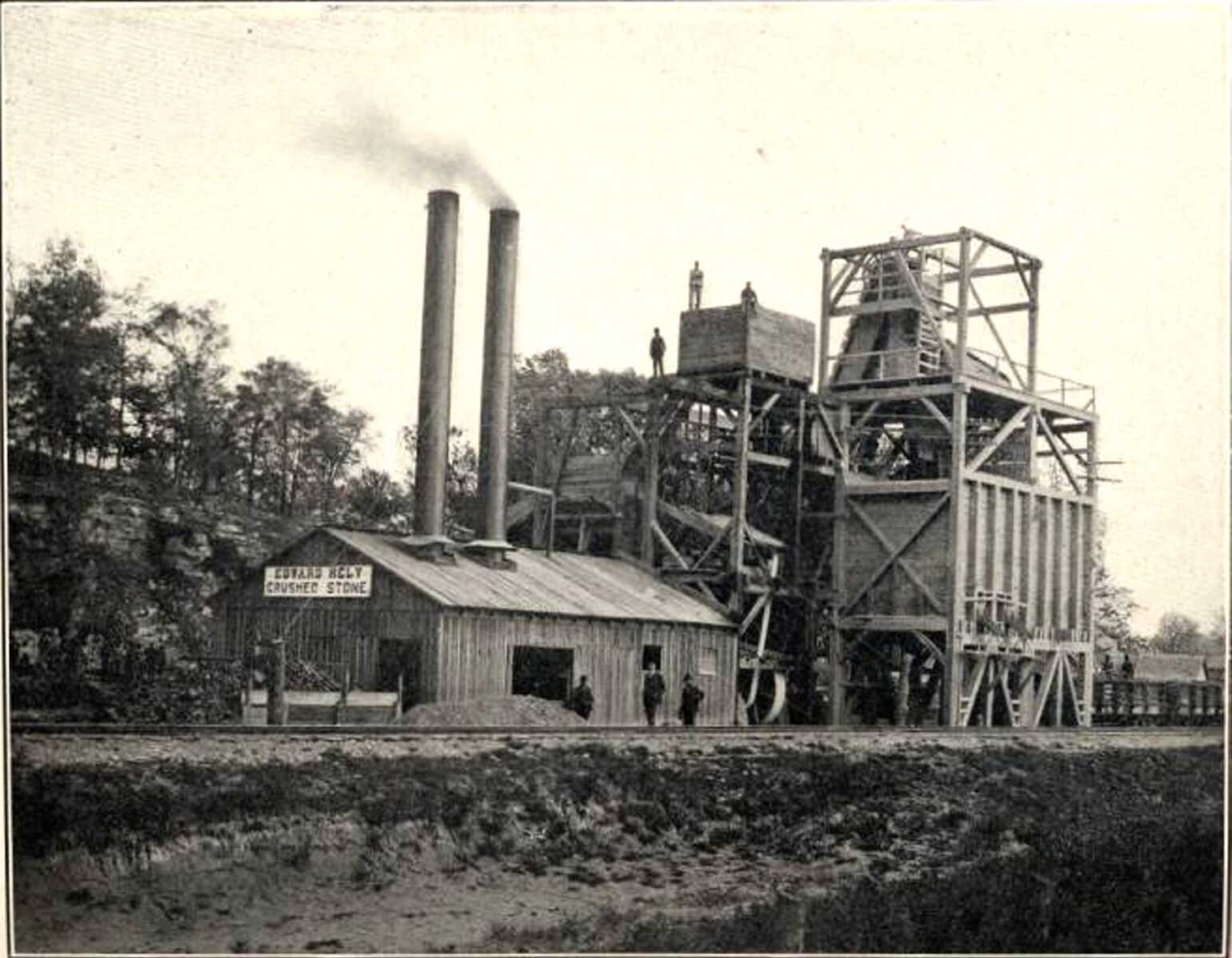 Edward Hely's Stone Company's first rock crusher, circa 1903, was powered by an engine and two 100-horse power boilers. Steam drills were used at the rock face, and stone was hauled to the crusher in mule-pulled steel cars, along tracks that radiated to all parts of the quarry. The plant also had a side track that connected with the St. Louis, Iron Mountain and Southern railroad. This photo was published in the Missouri Bureau of Geology and Mines magazine, Volume II, Series 2.