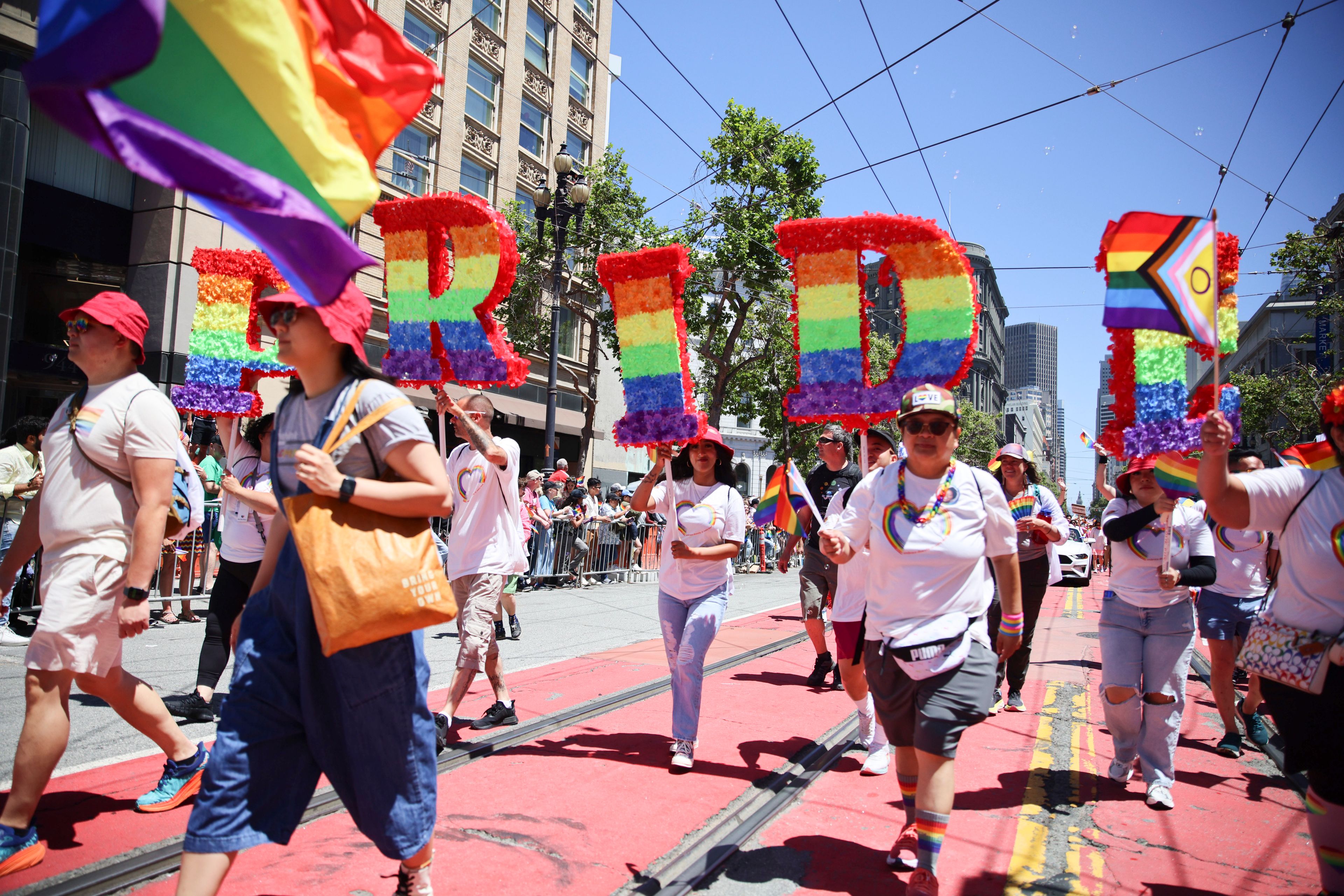 Revelers walk along Market Street during a Pride Parade, Sunday, June 30, 2024, in San Francisco. (AP Photo/Ethan Swope)