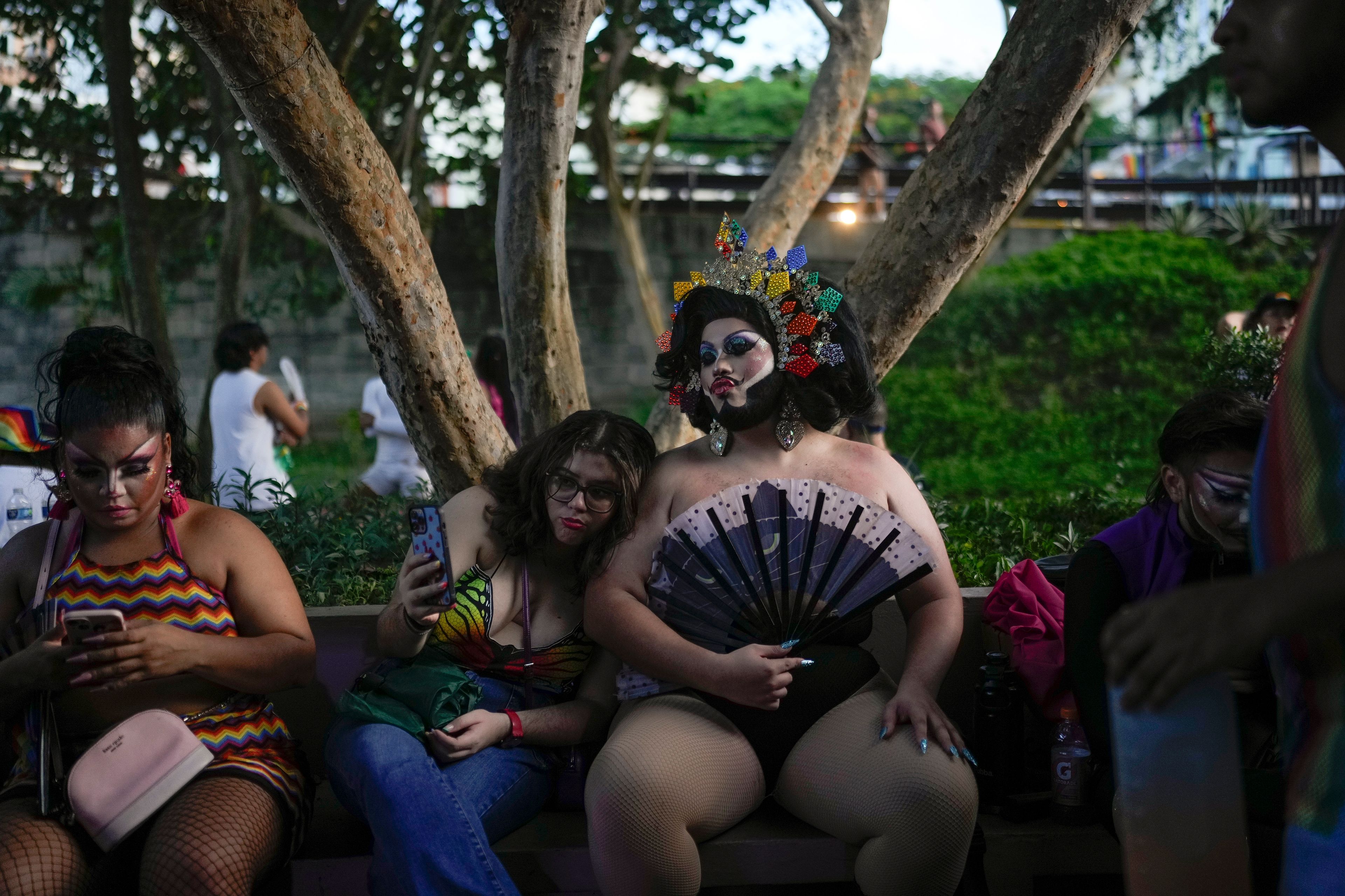 Revelers sit on a bench during a Pride parade marking the culmination of LGBTQ+ Pride month, in Panama City, Saturday, June 29, 2024. (AP Photo/Matias Delacroix)
