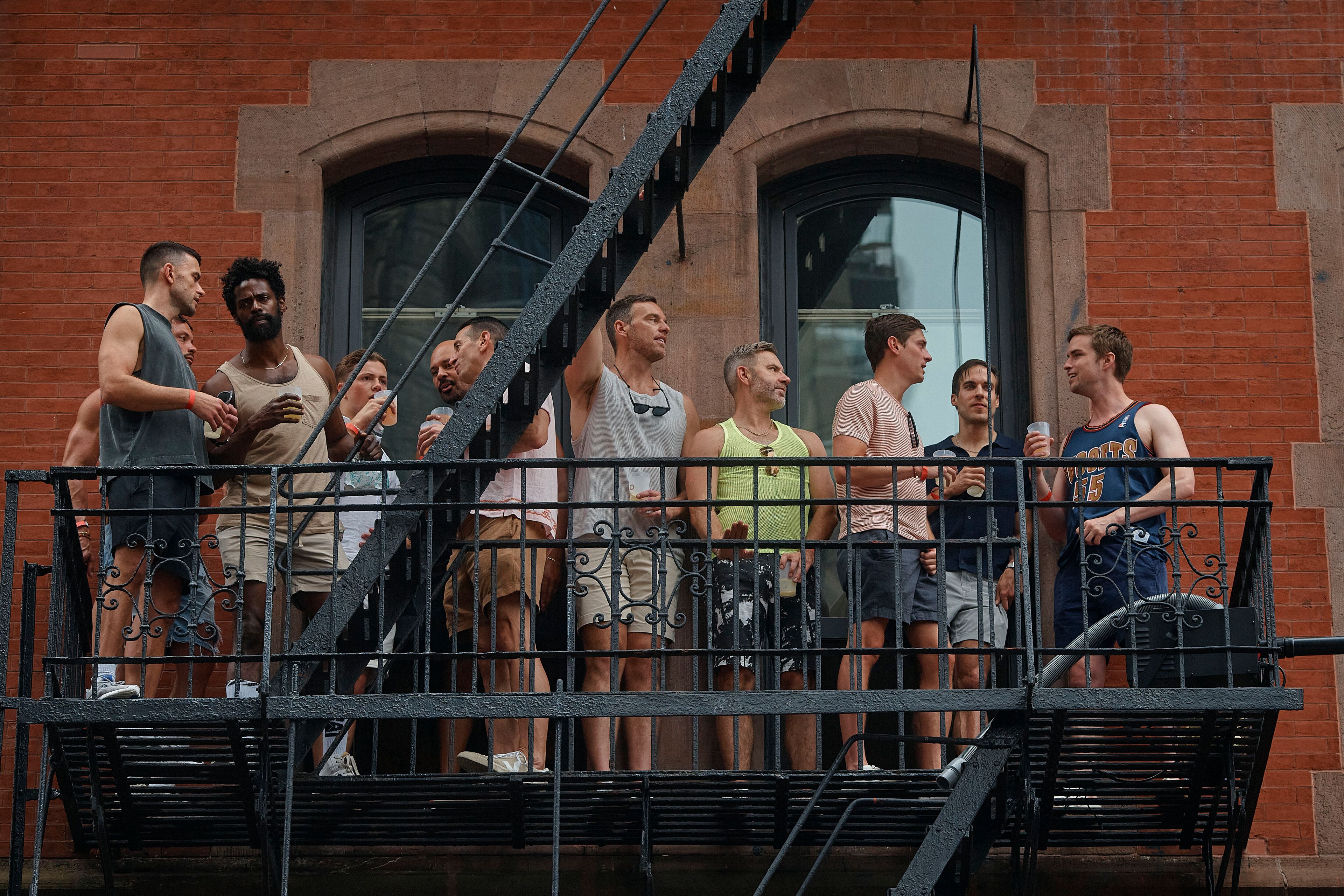 People watch the NYC Pride March from a fire escape, Sunday, June 30, 2024, in New York. (AP Photo/Andres Kudacki)