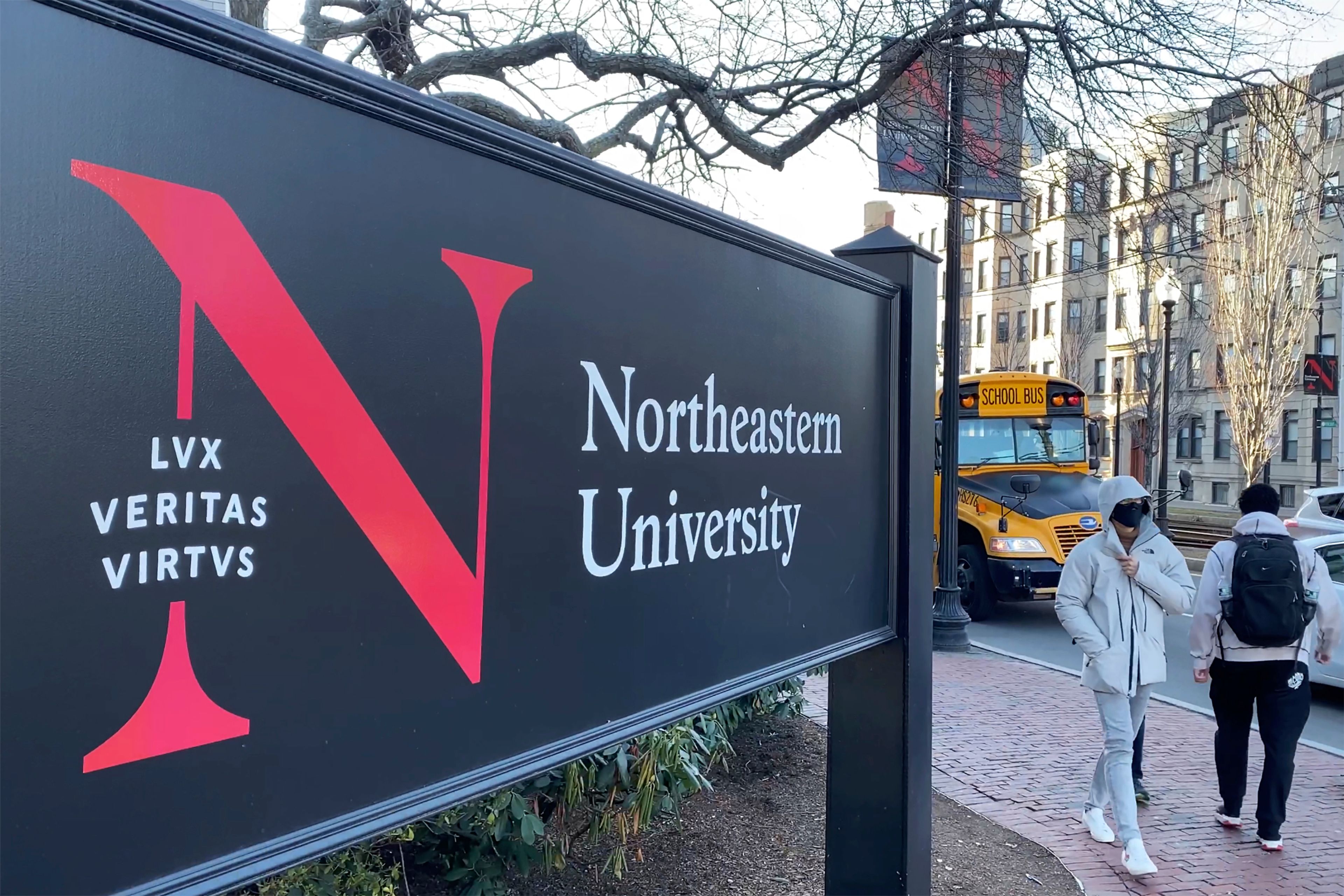 FILE - In this Jan. 31, 2019 file photo, pedestrians walk near a Northeastern University sign on the school's campus in Boston. A former lab manager at Northeastern University has been convicted, Friday, June 28, 2024, of staging a hoax explosion at the Boston campus and then lying about what happened to a federal agent. (AP Photo/Rodrique Ngowi, File)