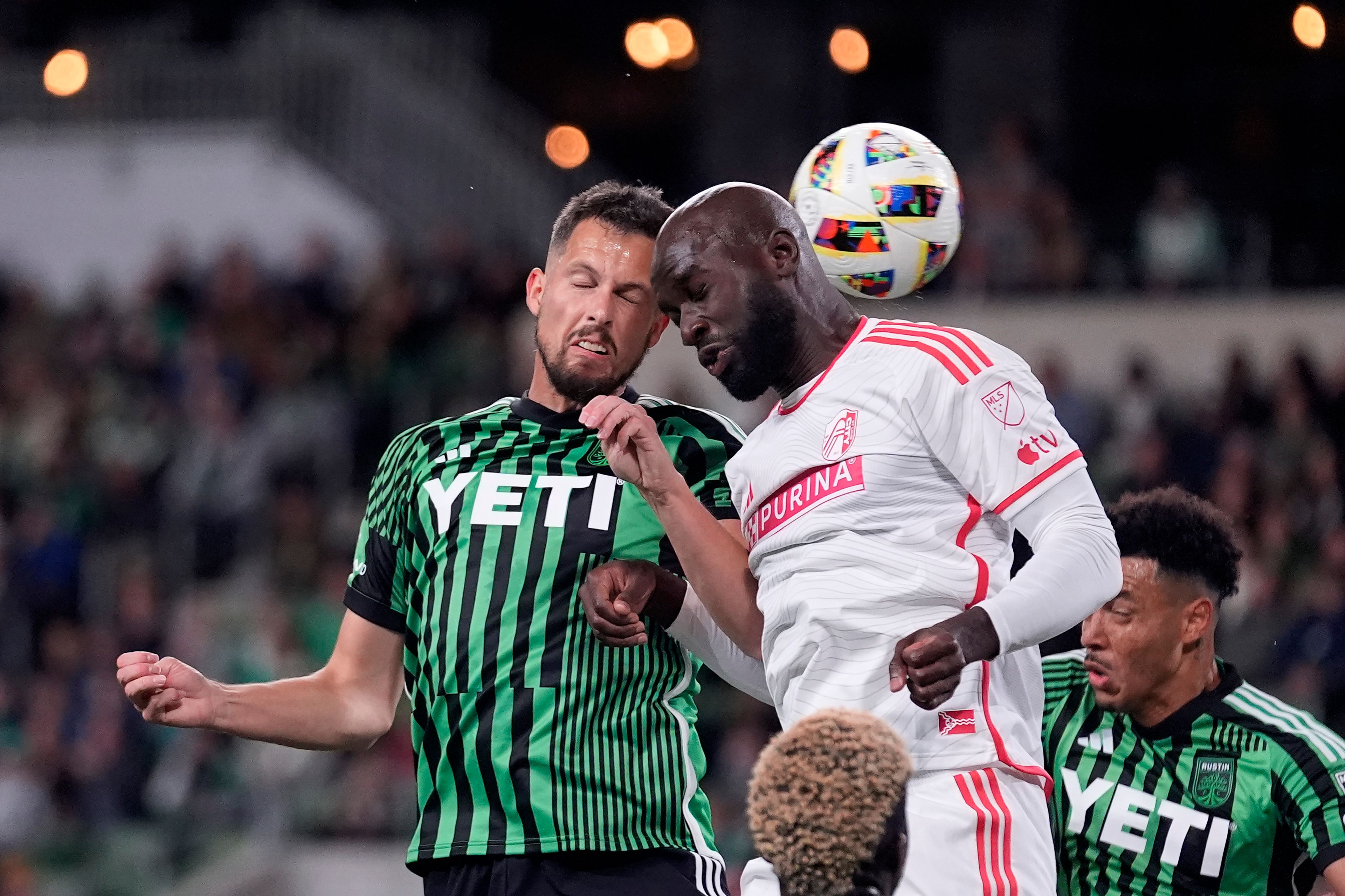Austin FC defender Matt Hedges, left, heads the ball to score past St. Louis City forward Samuel Adeniran, top right, during the first half of an MLS soccer match in Austin, Texas, Saturday, March 9, 2024. (AP Photo/Eric Gay)