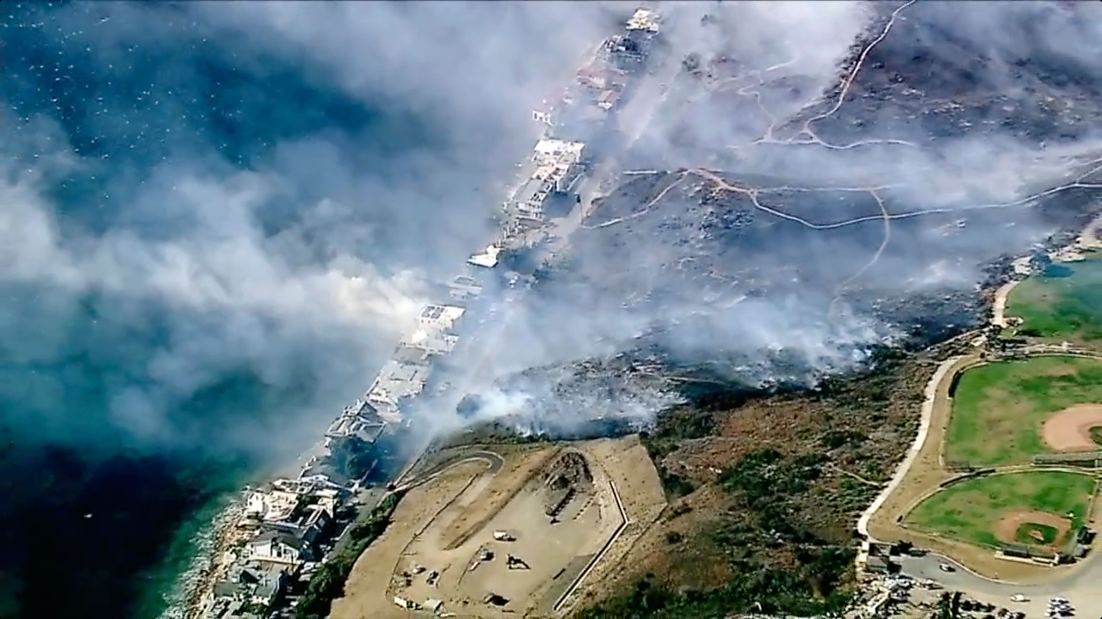 In this aerial still image provided by KABC-TV, shows Los Angeles County Fire Department crews scrambled to contain a small blaze fed by erratic wind gusts that pushed flames through dry brush near Broad Beach along Pacific Coast Highway in Malibu on Wednesday, Nov. 6, 2024. (KABC-TV via AP)