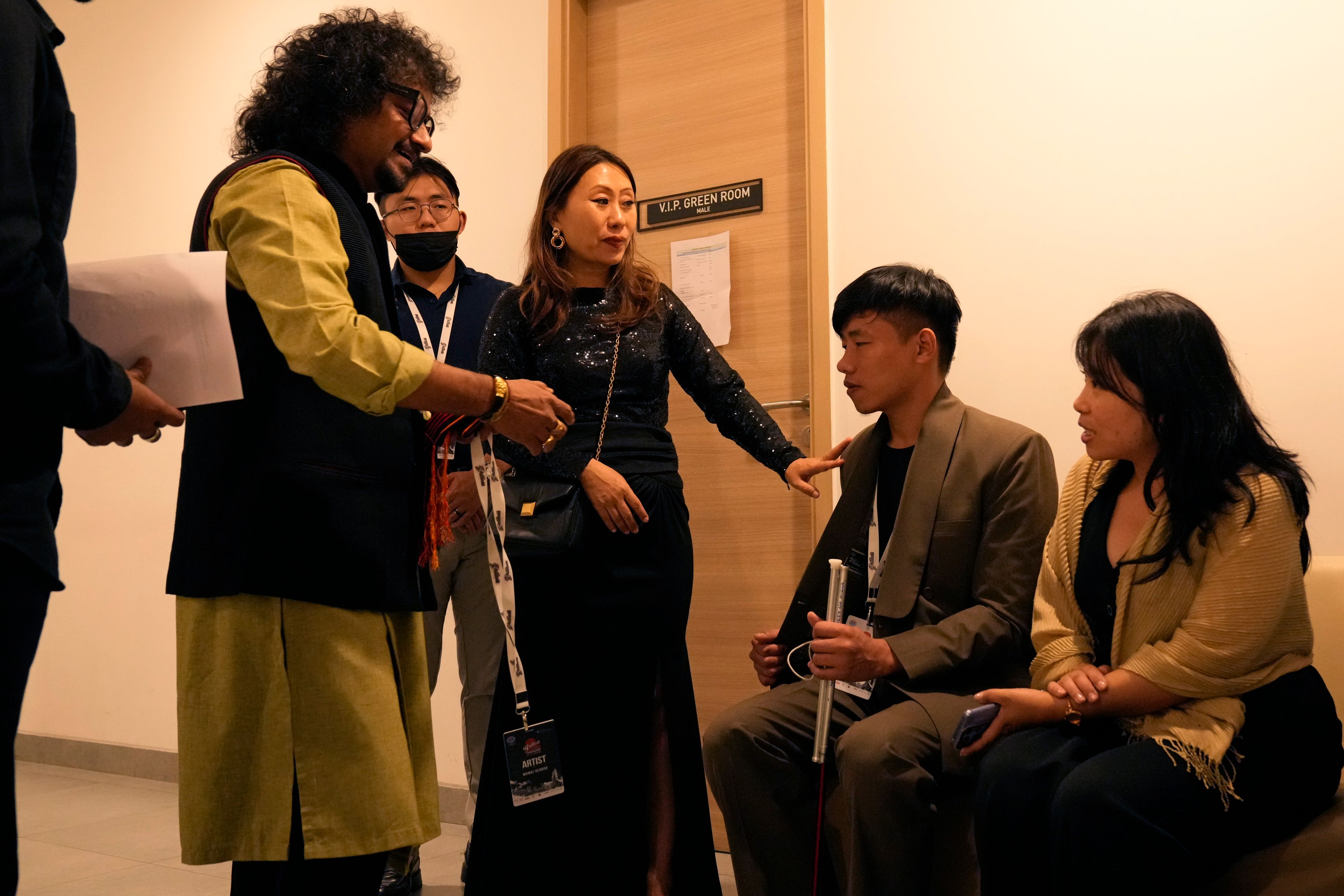 Takosangba Pongen, 27, a blind pianist, second right, is introduced to other artists by festival director Khyochano TCK, center, as he waits backstage for his performance at the two-day Brillante Piano Festival in Bengaluru, India, Sunday, Sept. 29, 2024. (AP Photo/Aijaz Rahi)