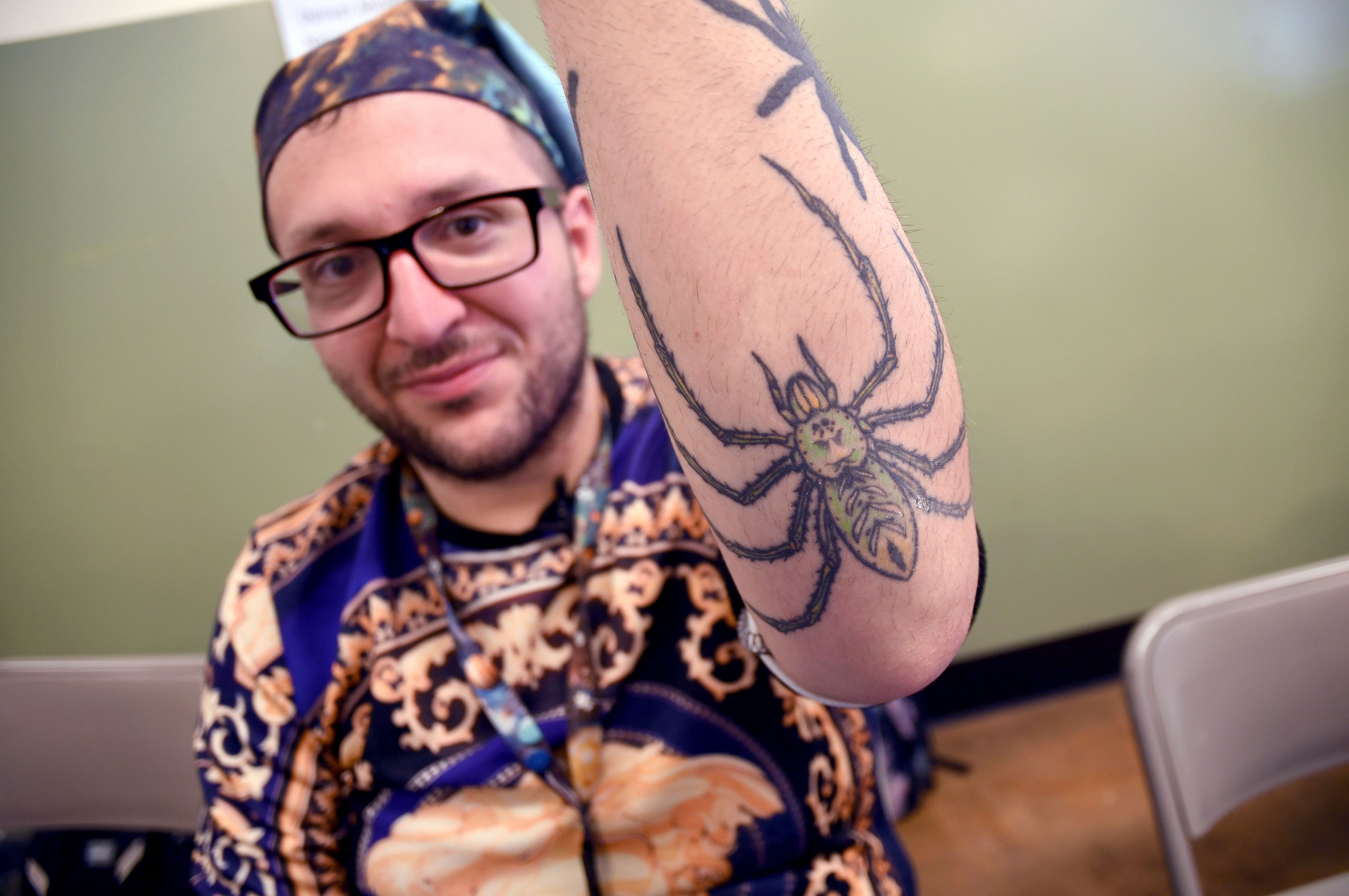 Goran Shikak, an arachnology graduate student at The University of Colorado Denver, shows off his spider tattoos during the Tarantula Festival in La Junta, Colo., Saturday, Sept. 28, 2024. (AP Photo/Thomas Peipert)