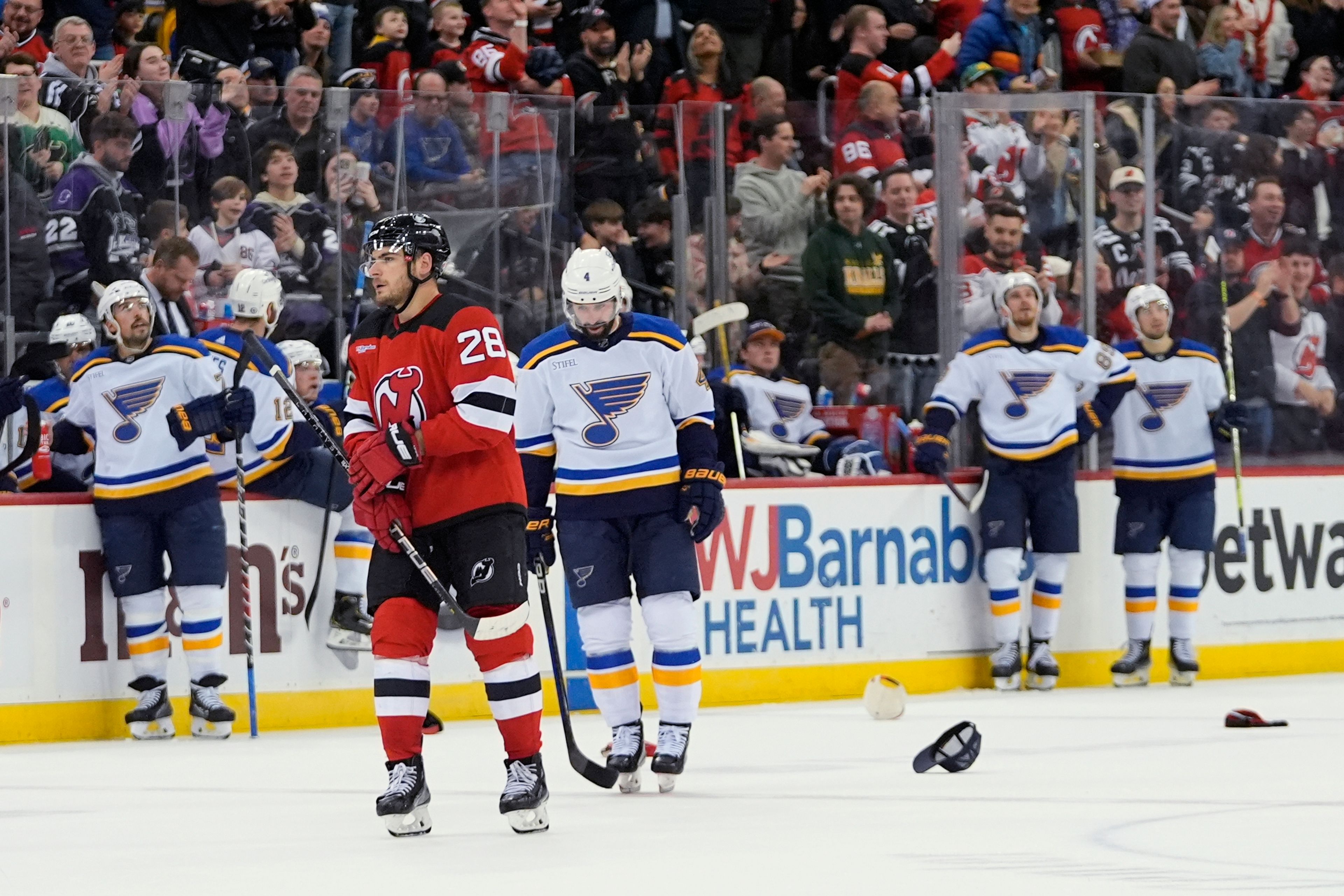 St. Louis Blues pause as fans toss hats on the ice after New Jersey Devils' Timo Meier (28) scored his third goal, during the second period of an NHL hockey game Thursday, March 7, 2024, in Newark, N.J. (AP Photo/Frank Franklin II)