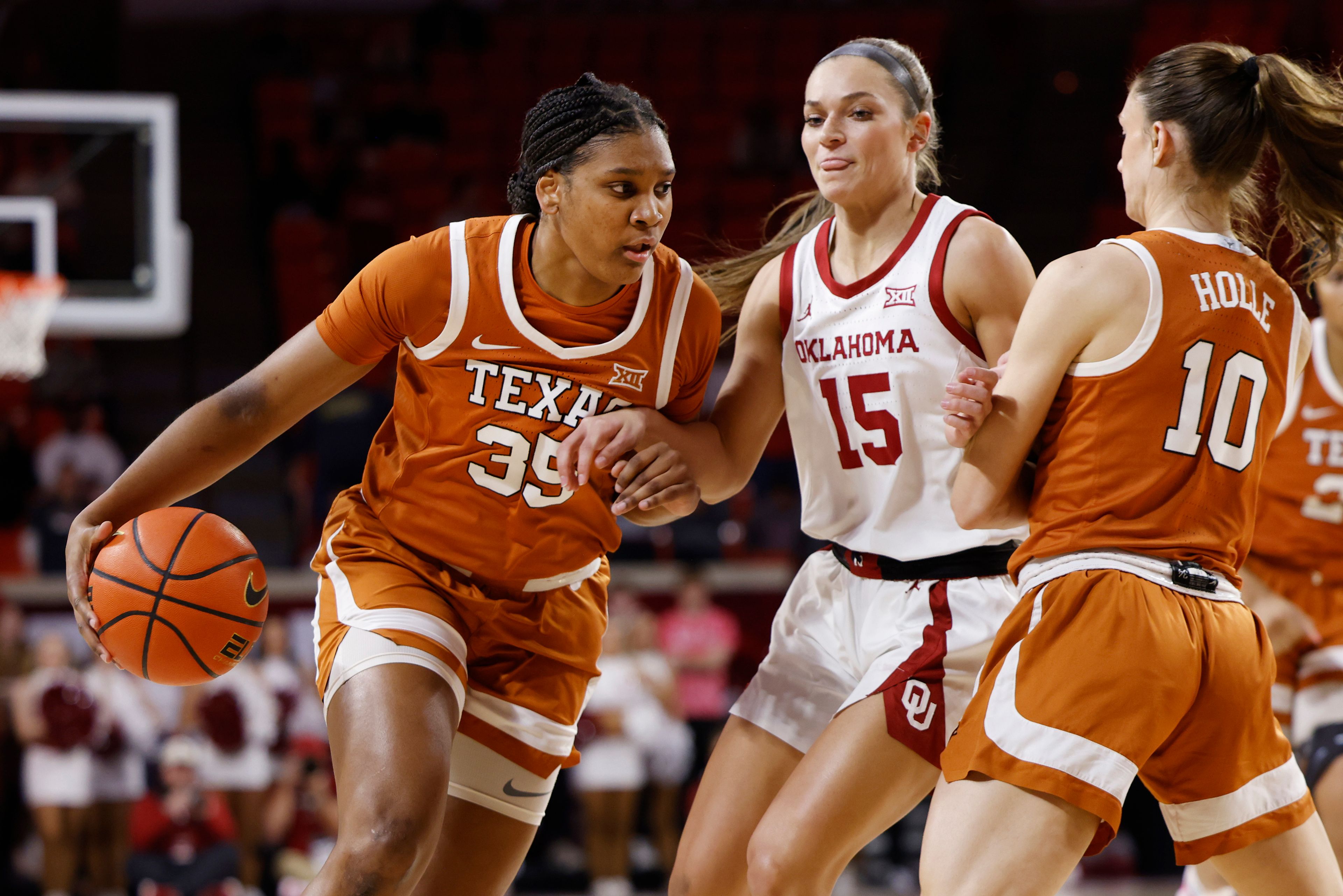 Texas forward Madison Booker (35) drives the ball against Oklahoma guard Lexy Keys (15), guarded by Texas guard Shay Holle (10), during the first half of an NCAA college basketball game Wednesday, Feb. 28, 2024, in Norman, Okla. (AP Photo/Garett Fisbeck)