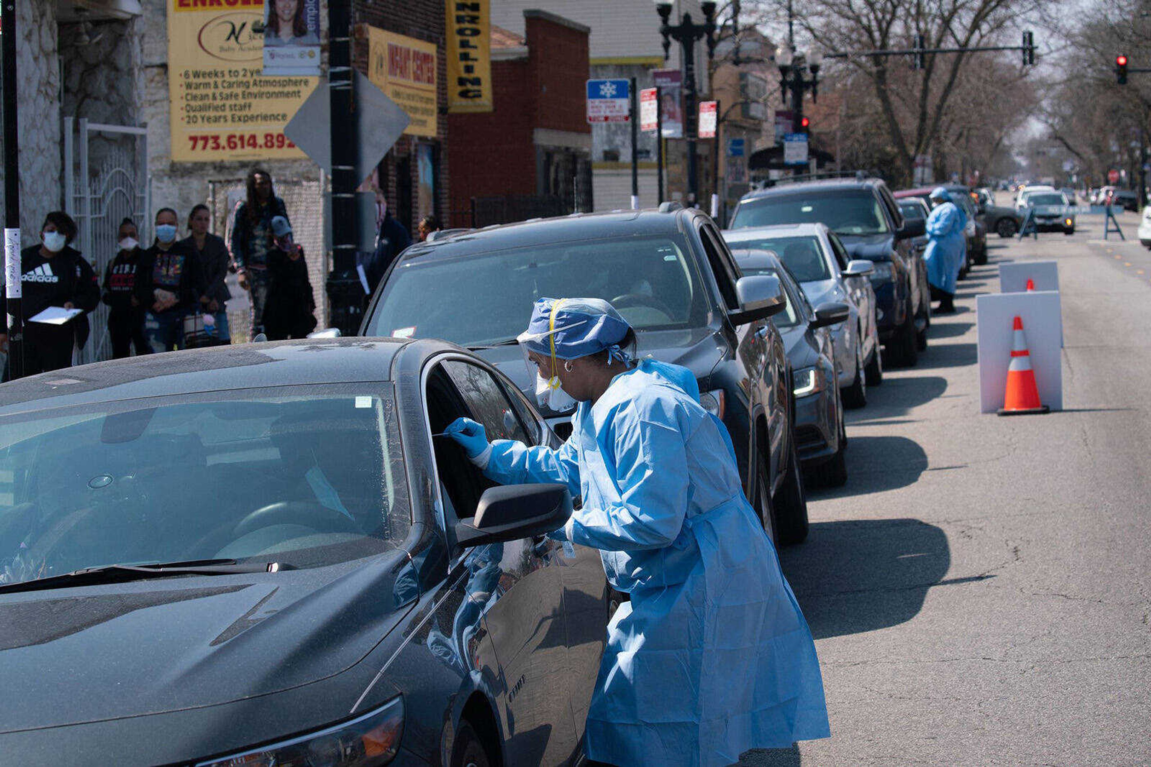 People wait in line in their cars to get tested for COVID-19 at Roseland Community Hospital in Chicago on April 3, 2020.