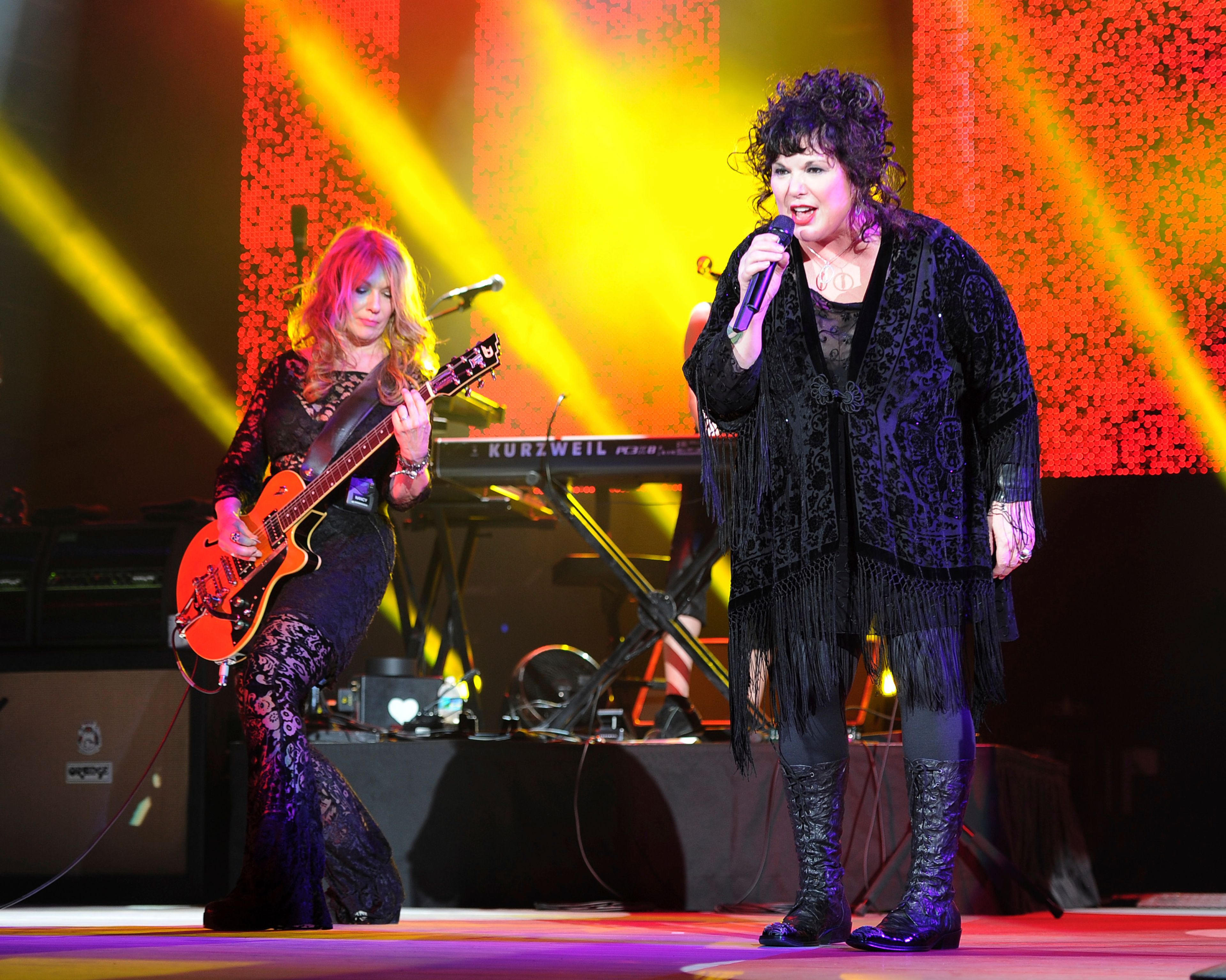 FILE - Nancy Wilson, left, and Ann Wilson of Heart perform on opening night of the Heartbreaker Tour at the Cruzan Amphitheater in West Palm Beach, Fla., June 17, 2013. Ann Wilson, lead singer of rock band Heart, says she has cancer. The band is postponing the remaining shows on its Royal Flush Tour. Wilson said in a statement Tuesday that she underwent a surgery to remove a cancerous growth and is recovering steadily, but that her doctors urged her to undergo preventive chemotherapy and take time off from performing. (Photo by Jeff Daly/Invision/AP, File)