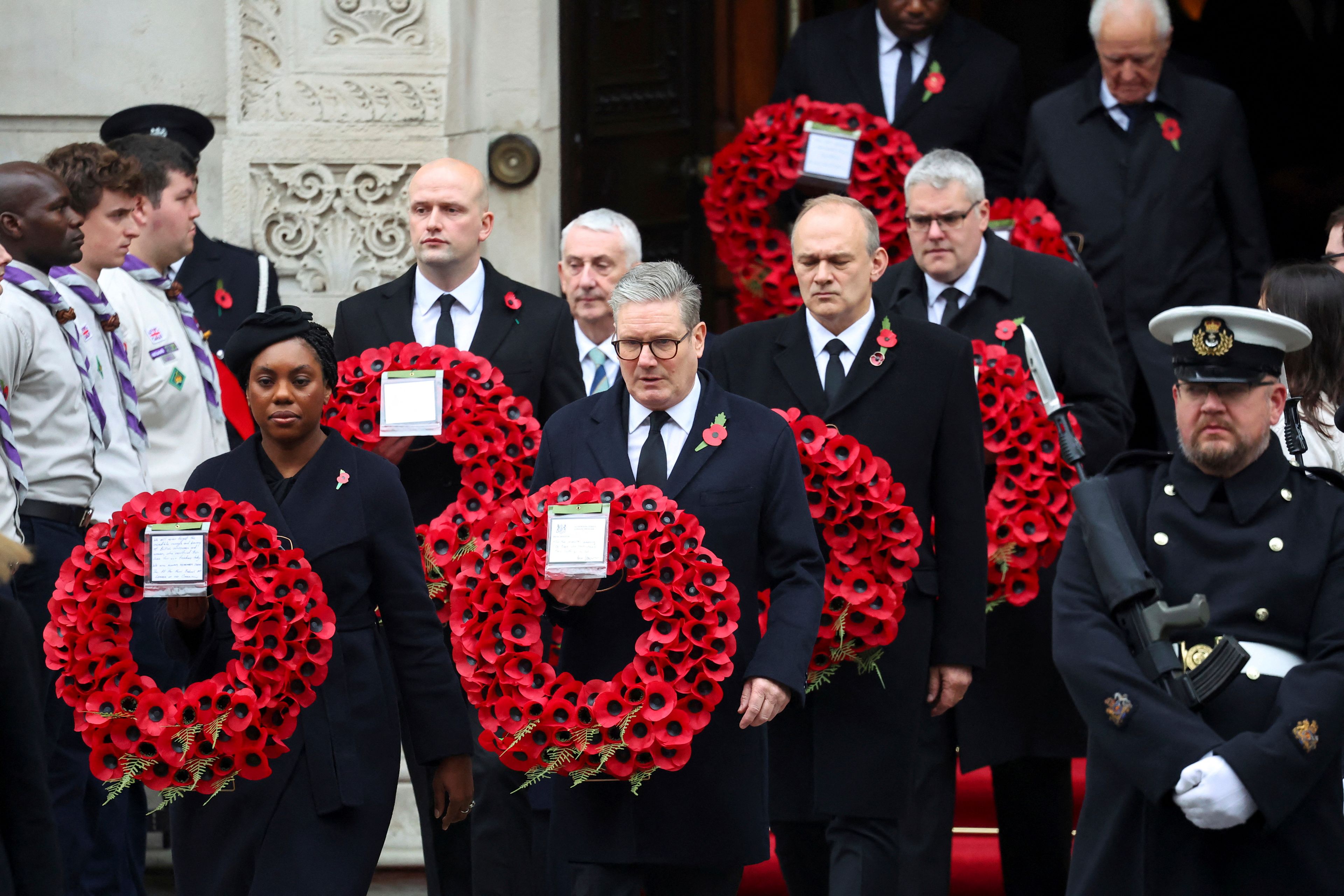 British Prime Minister Keir Starmer, front right, and Conservative Party leader Kemi Badenoch, front left, carry wreaths as they attend the annual Remembrance Sunday ceremony at The Cenotaph in London, England, Sunday, Nov. 10, 2024. (Toby Melville/Pool Photo via AP)