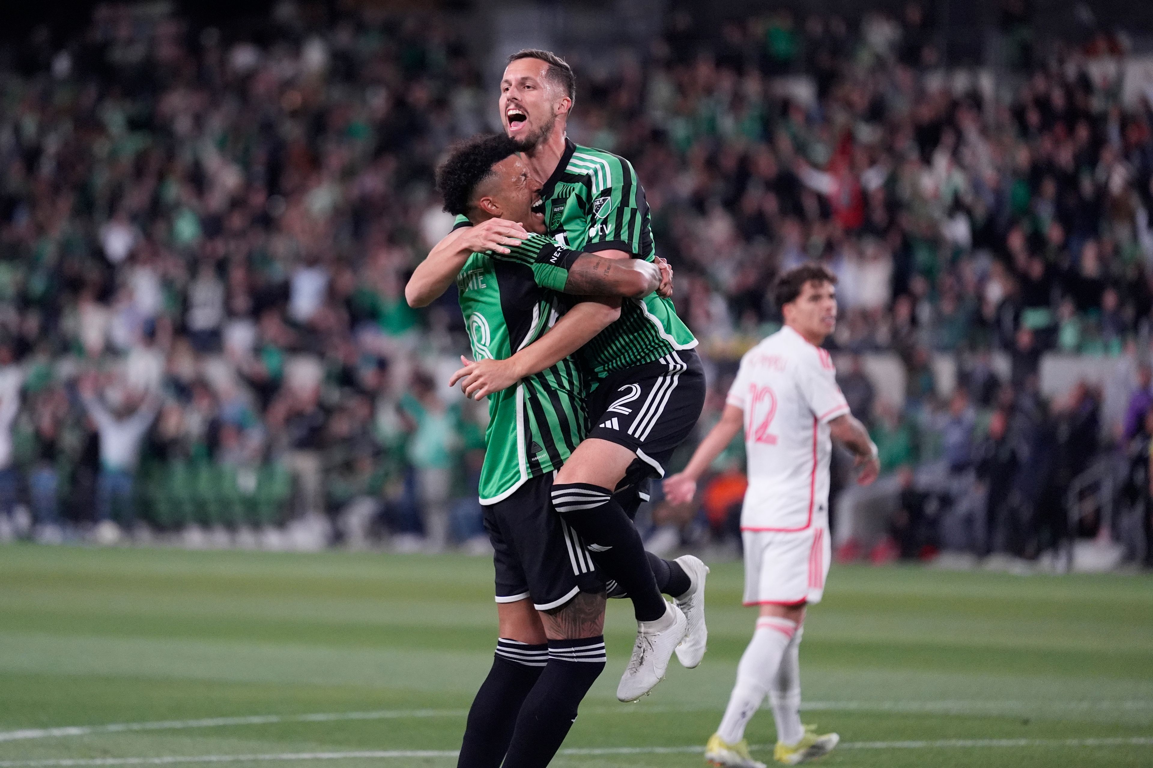 Austin FC defender Matt Hedges (2) leaps into the arms of teammate Julio Cascante after he scored against St. Louis City during the first half of an MLS soccer match in Austin, Texas, Saturday, March 9, 2024. (AP Photo/Eric Gay)