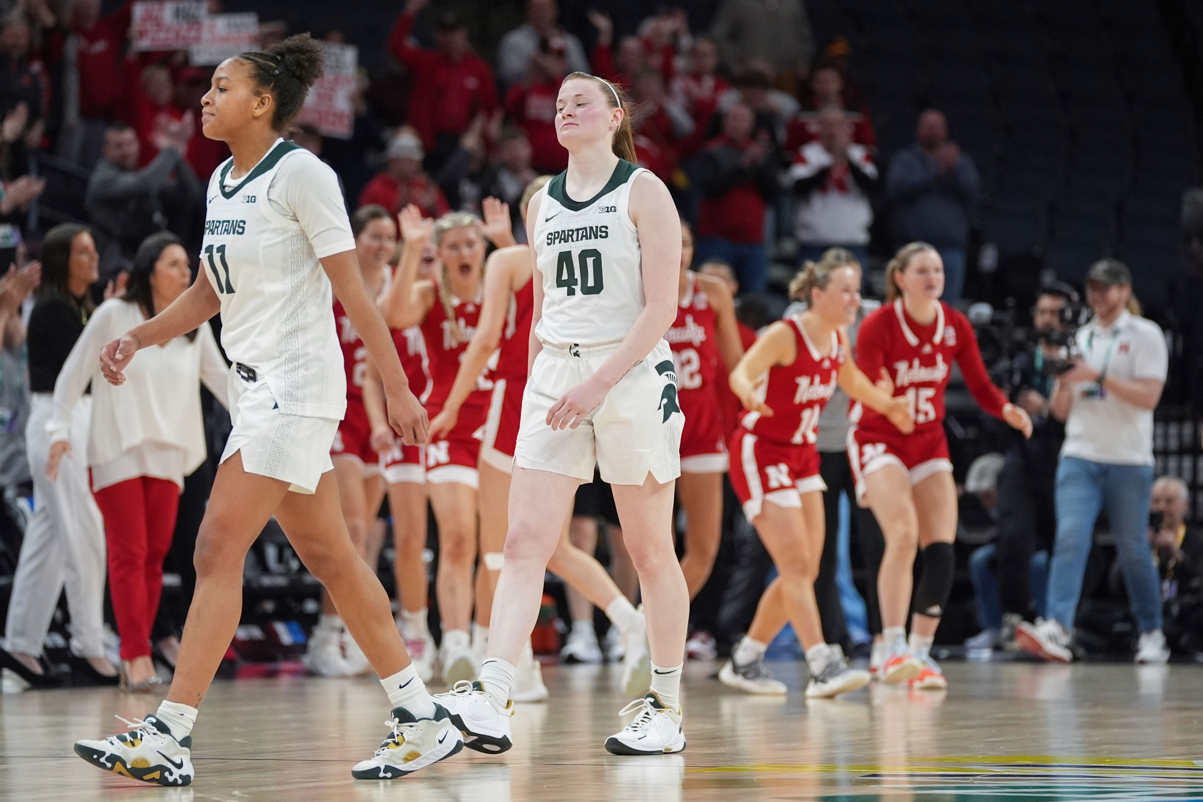 Michigan State guards Jocelyn Tate (11) and Julia Ayrault (40) walk off the court after a loss to Nebraska during an NCAA college basketball quarterfinal game at the Big Ten women's tournament Friday, March 8, 2024, in Minneapolis. (AP Photo/Abbie Parr)