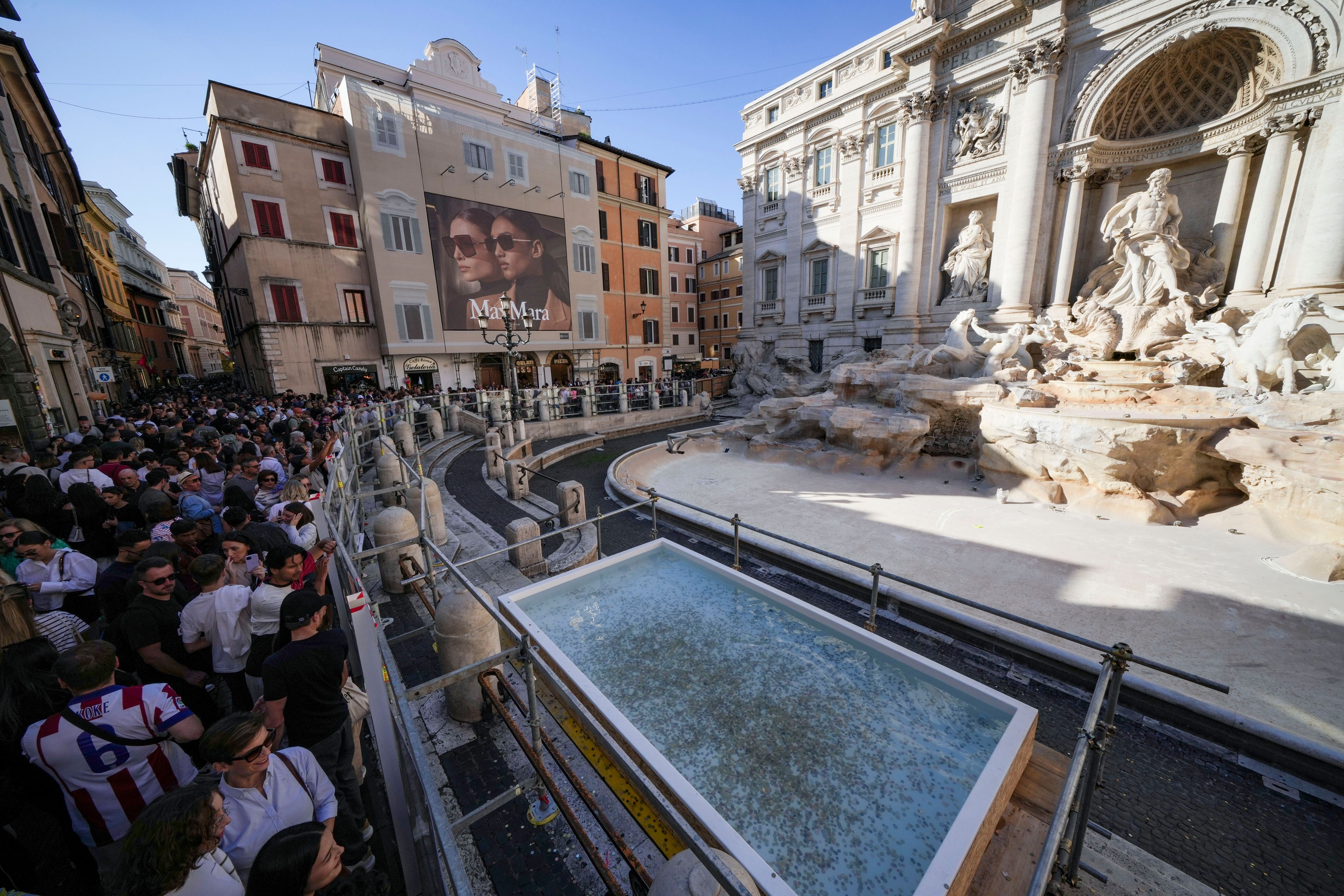 A small pool is seen in front of the Trevi Fountain to allow tourists to throw their coins in it, as the fountain has been emptied to undergo maintenance work that it is expected to be completed by the end of the year, in Rome, Friday, Nov. 1, 2024. (AP Photo/Andrew Medichini)