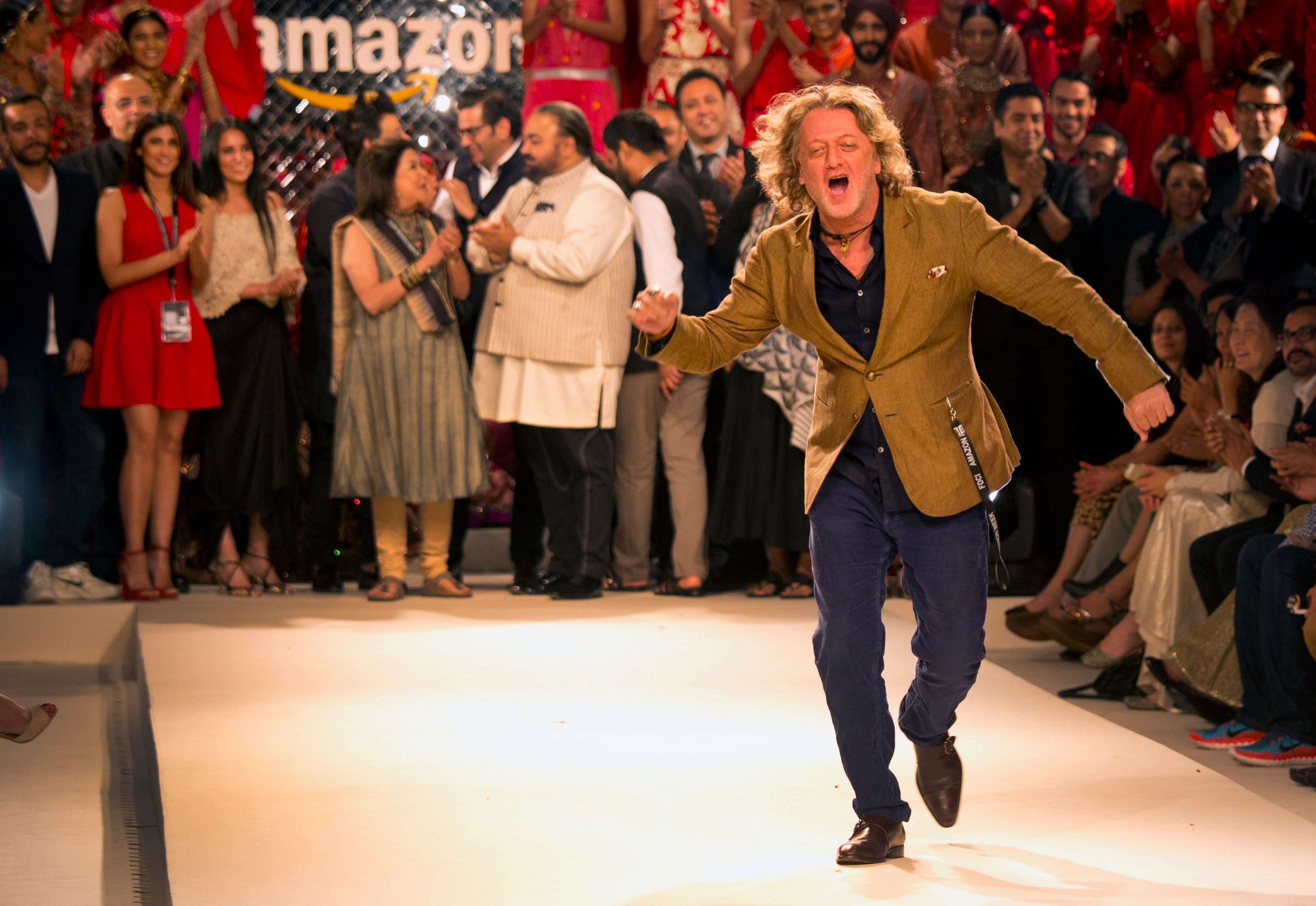 FILE - Fashion designer Rohit Bal dances as other designers watch during the grand finale of Amazon India fashion week in New Delhi, India, Sunday, March 29, 2015. (AP Photo/Manish Swarup, File)