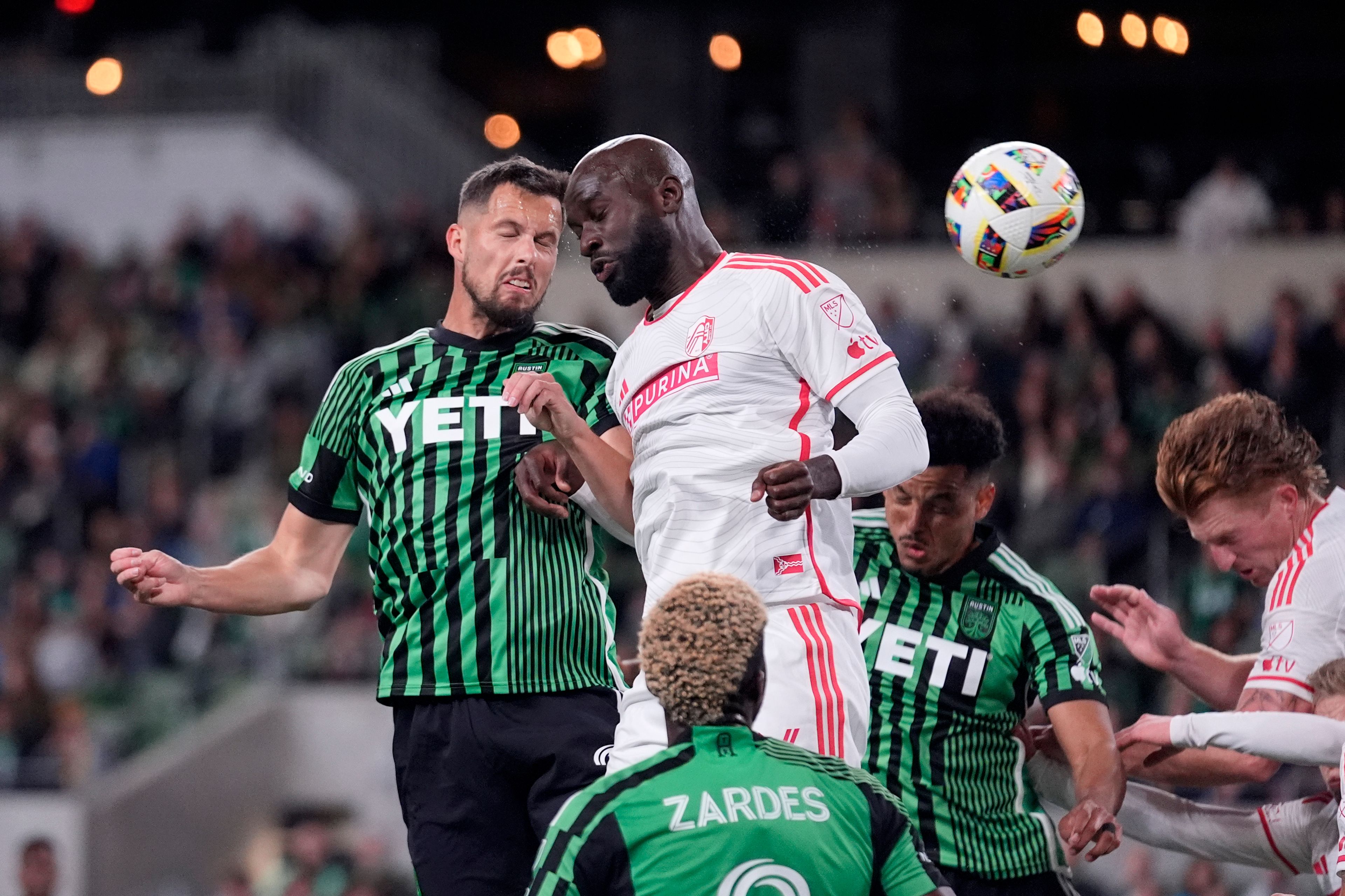 Austin FC defender Matt Hedges, left, heads the ball to score past St. Louis City forward Samuel Adeniran, center, during the first half of an MLS soccer match in Austin, Texas, Saturday, March 9, 2024. (AP Photo/Eric Gay)