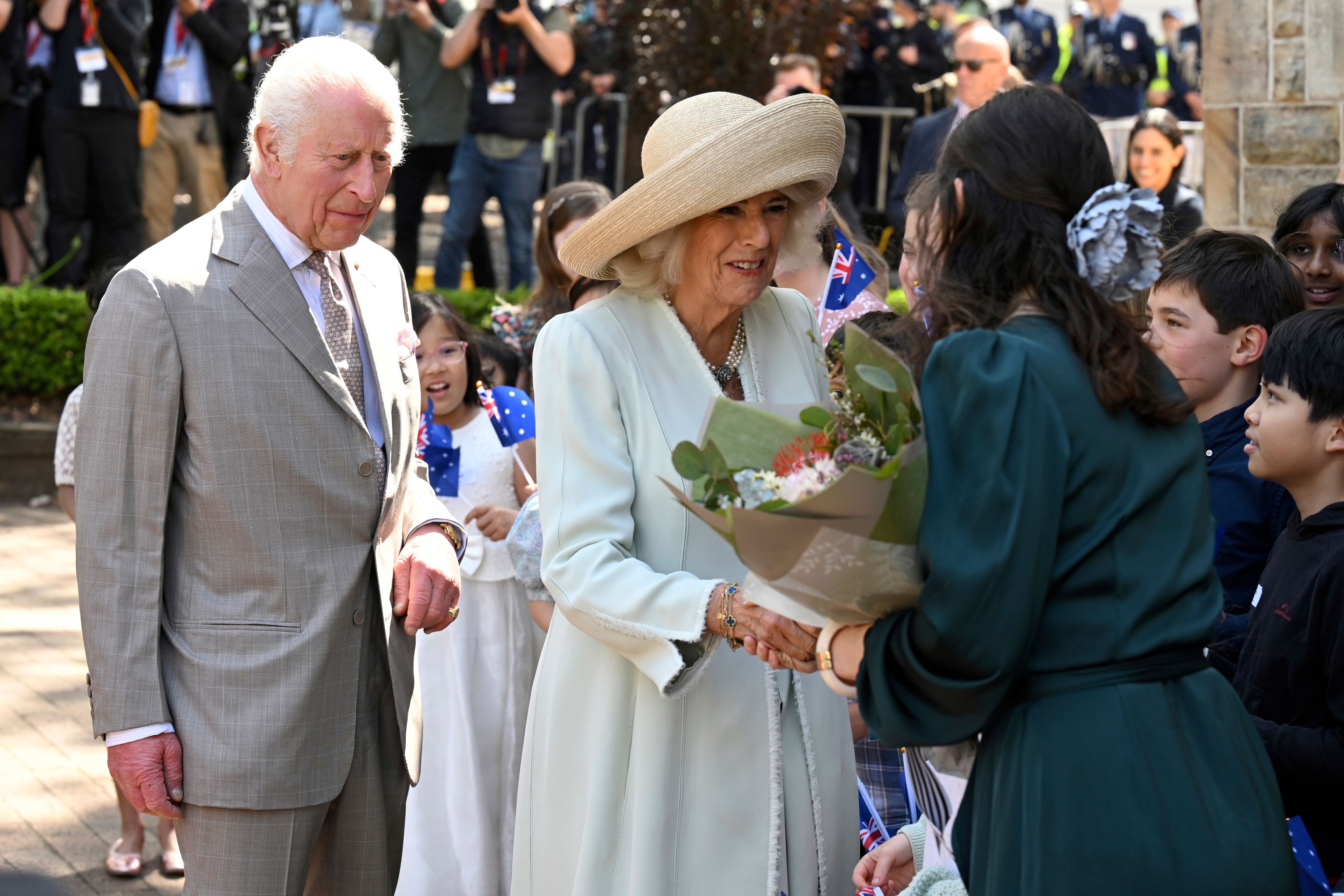 Children greet King Charles III and Queen Camilla outside a Sydney church