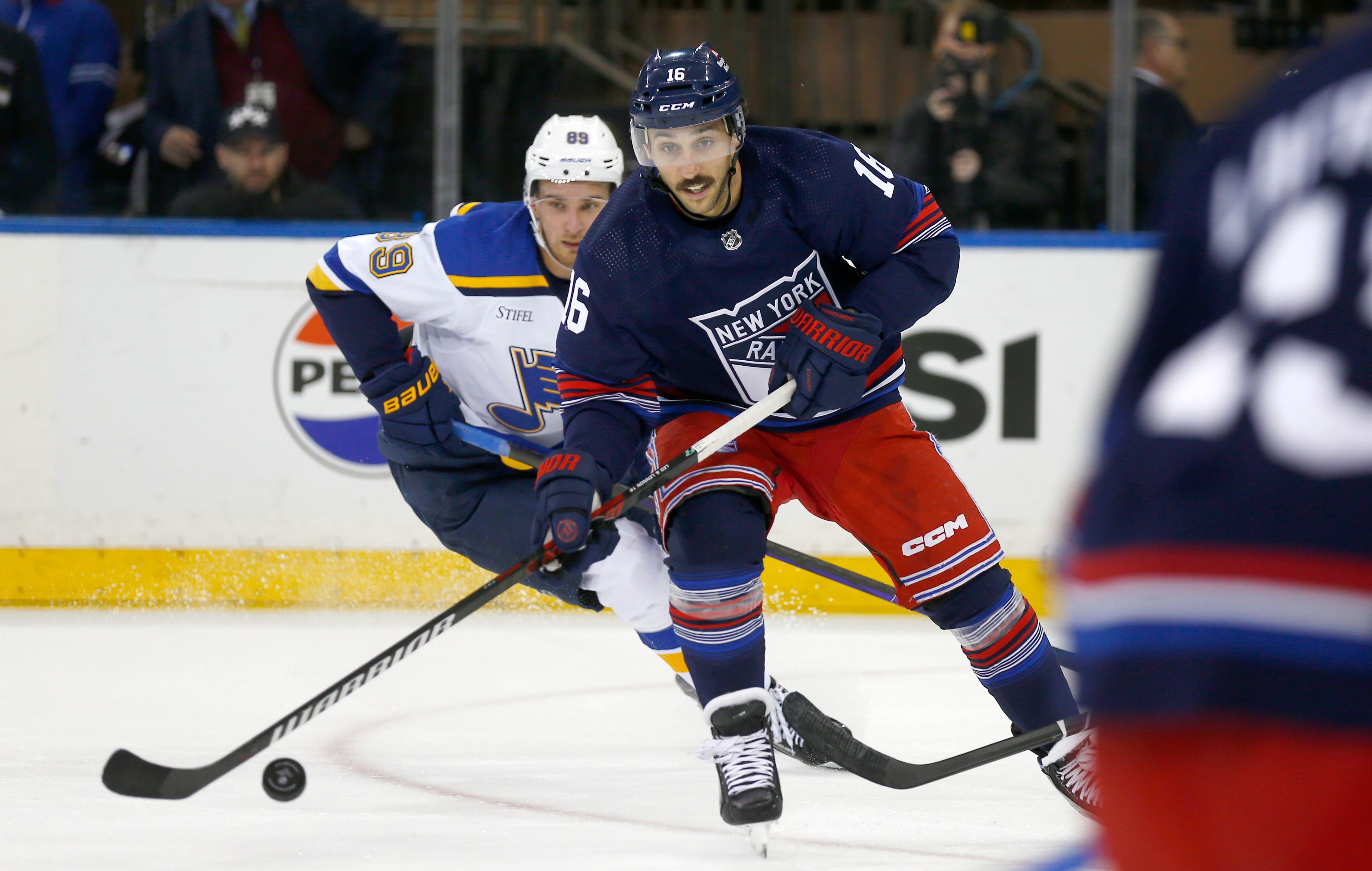 New York Rangers center Vincent Trocheck (16) controls the puck while pursued by St. Louis Blues forward Pavel Buchnevich (89) during the first period of an NHL hockey game Saturday, March 9, 2024, in New York. (AP Photo/John Munson)
