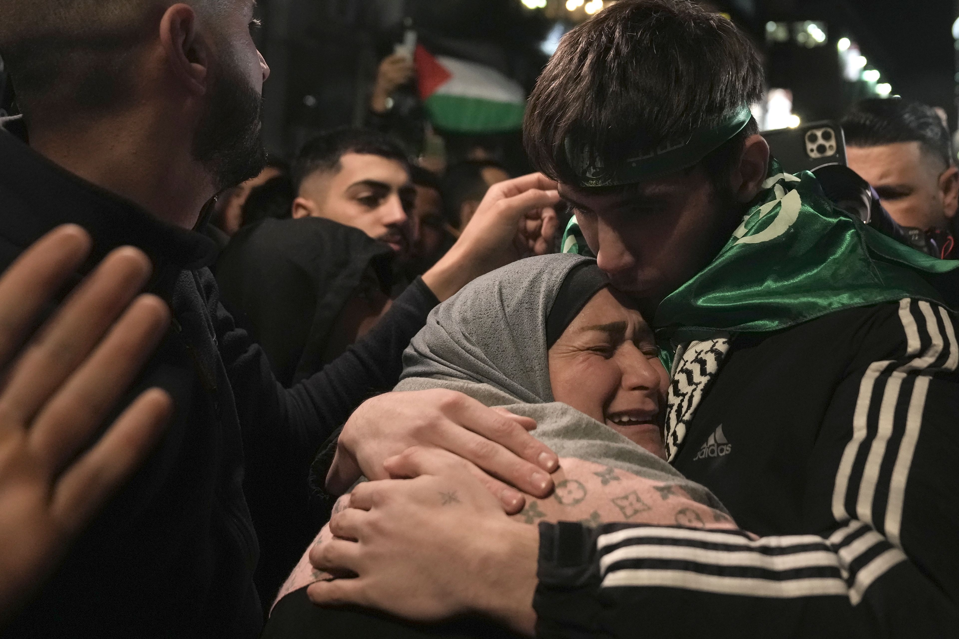 Omar Atshan, 17, is hugged by his mother after being released from an Israeli prison in the West Bank town of Ramallah, Sunday Nov. 26, 2023. Israel released 39 Palestinian prisoners in a third exchange of hostages for prisoners with Hamas Sunday. (AP Photo/Nasser Nasser)