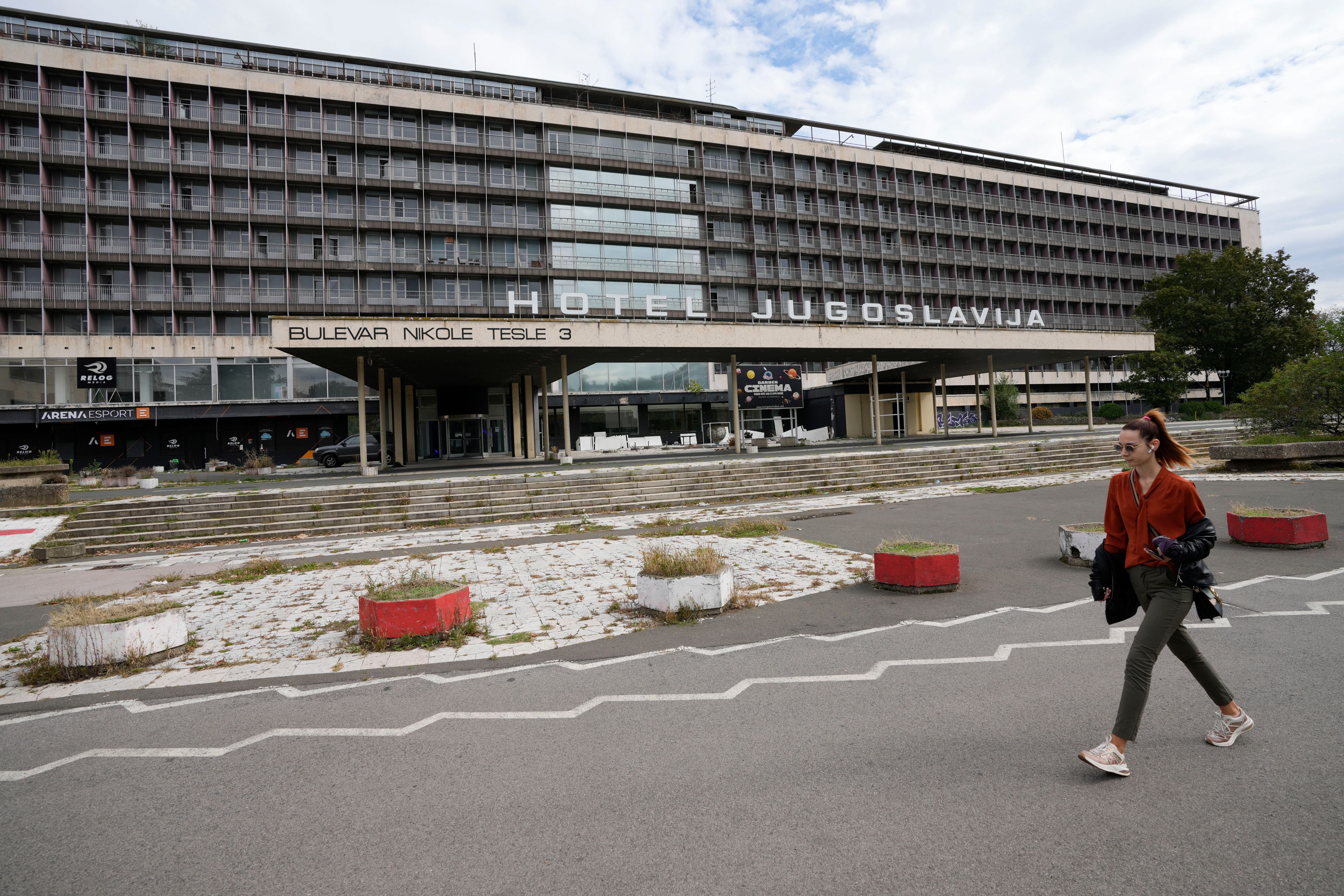 A woman walks past Hotel Yugoslavia, once a symbol of progress in the former socialist state of Yugoslavia that broke apart in the 1990s and a favorite gathering place for local residents as well as world leaders, in Belgrade, Serbia, Thursday, Oct. 3, 2024. (AP Photo/Darko Vojinovic)