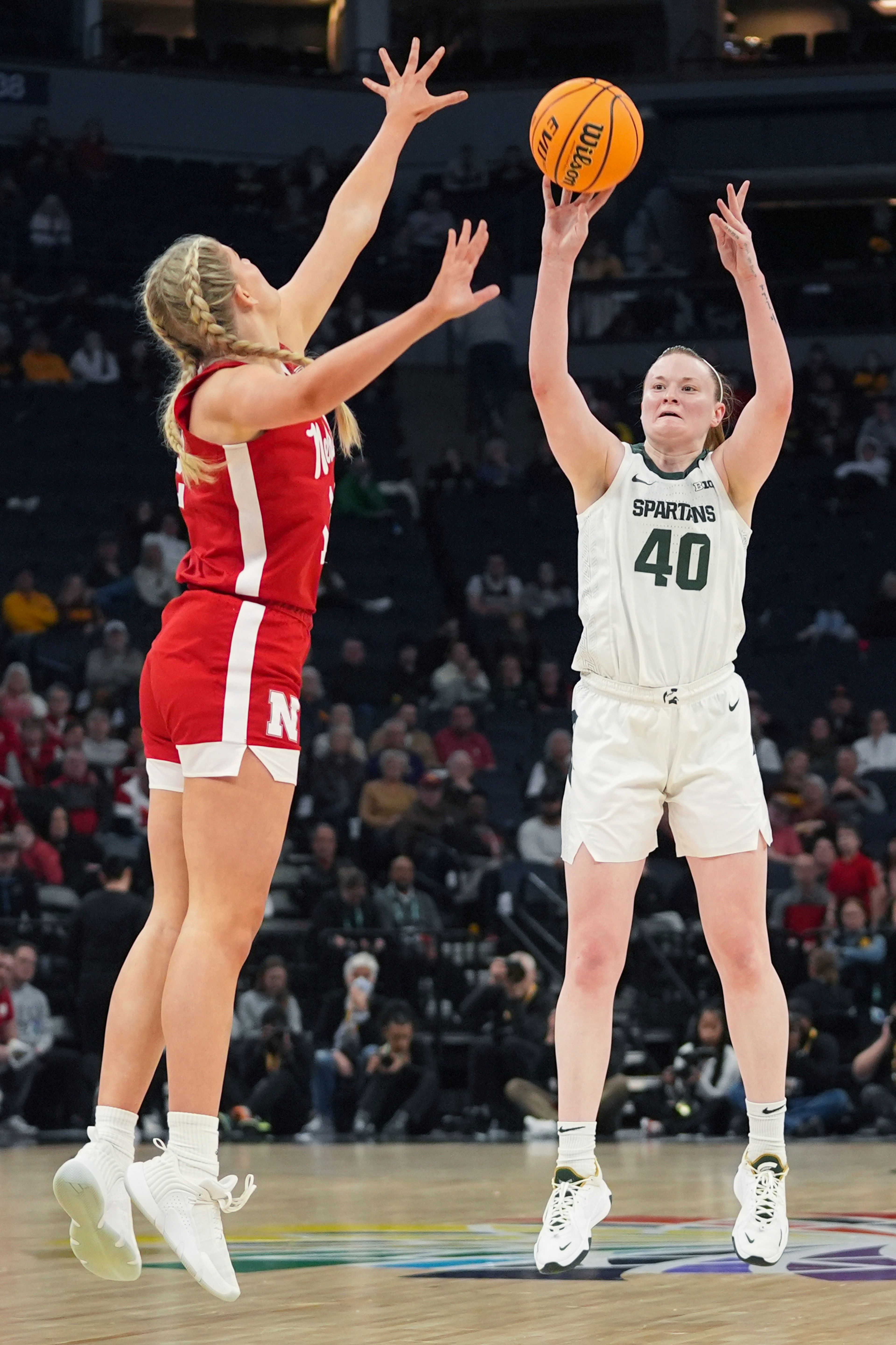 Michigan State guard Julia Ayrault (40) shoots over Nebraska forward Jessica Petrie during the second half of an NCAA college basketball quarterfinal game at the Big Ten women's tournament Friday, March 8, 2024, in Minneapolis. (AP Photo/Abbie Parr)