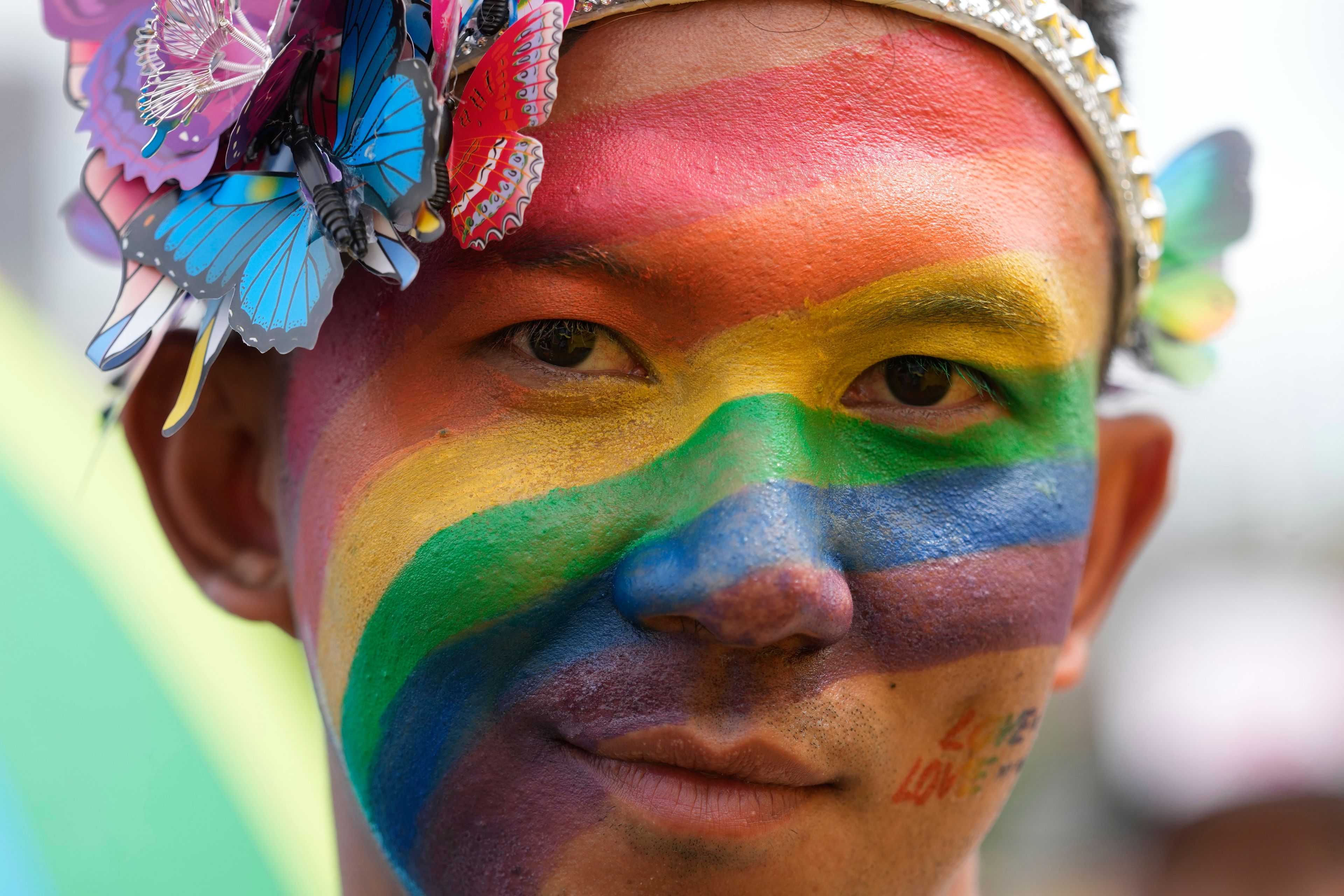 A participant with a rainbow painted on his face takes part in the Pride Parade in Bangkok, Thailand, Saturday, June 1, 2024. (AP Photo/Sakchai Lalit)