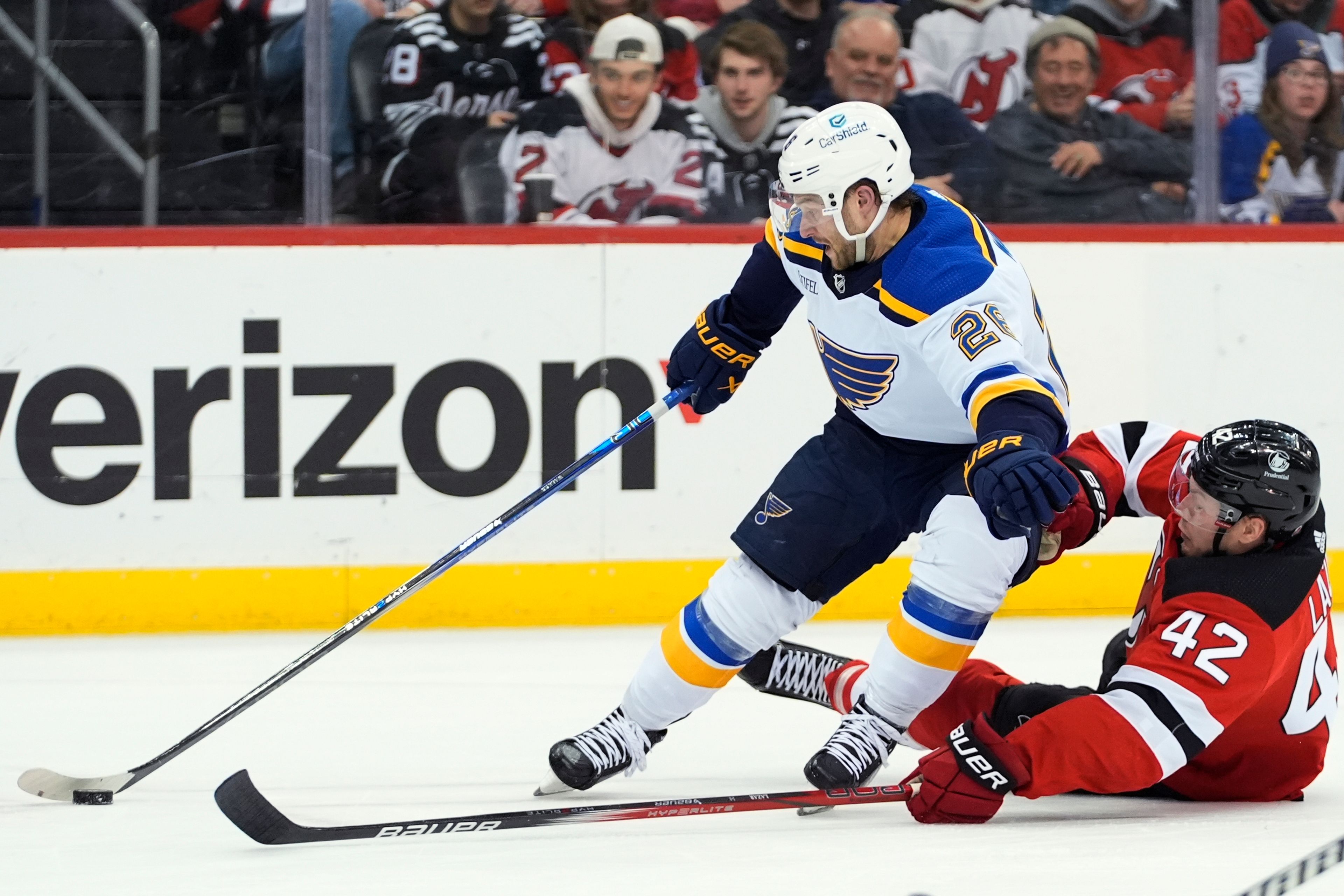 St. Louis Blues' Nathan Walker (26) skates past New Jersey Devils' Curtis Lazar (42) during the first period of an NHL hockey game Thursday, March 7, 2024, in Newark, N.J. (AP Photo/Frank Franklin II)