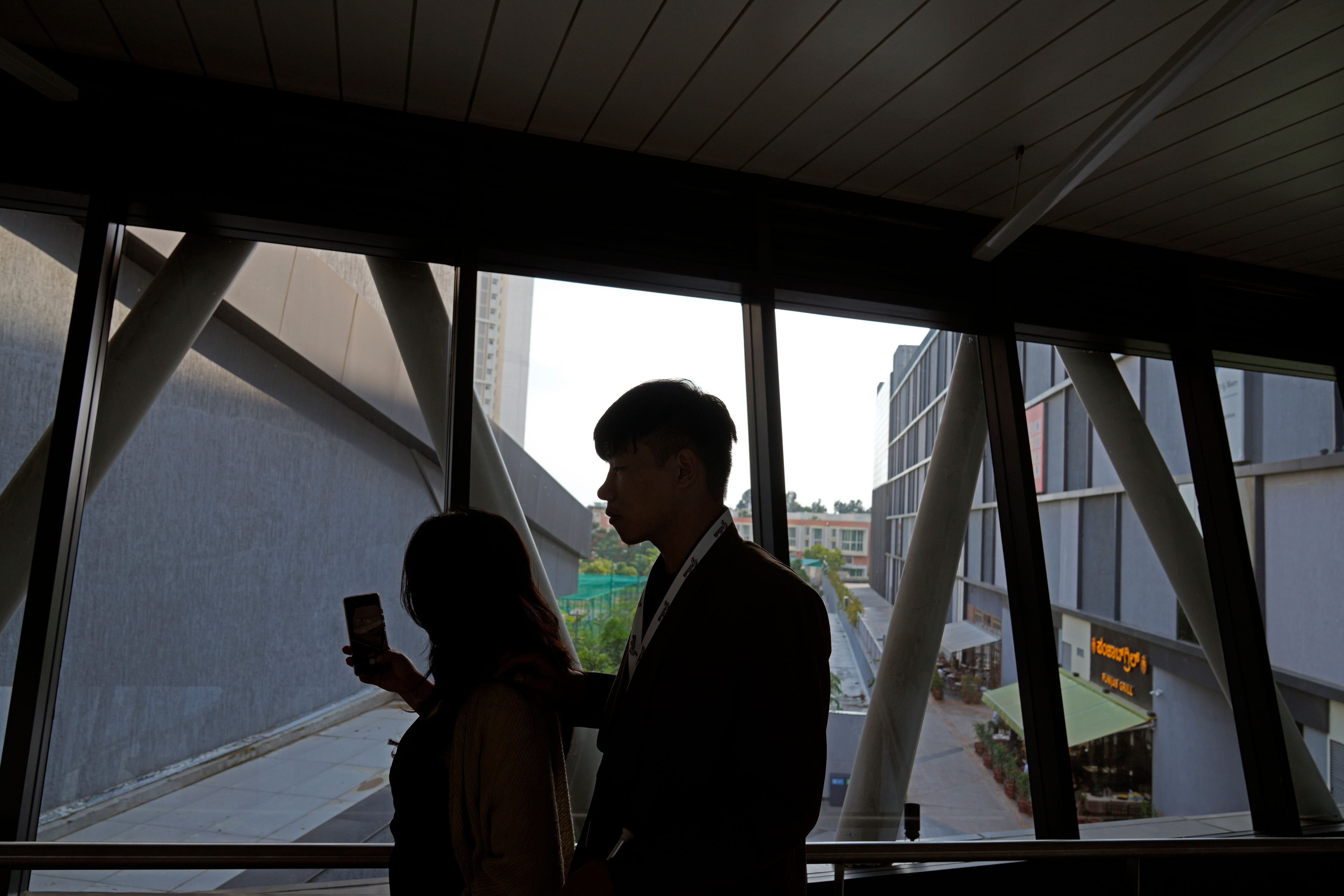 Imlibenla Jamir, 30, left, guides her brother Takosangba Pongen, 27, a blind pianist, through a passageway towards an auditorium during the two-day Brillante Piano Festival in Bengaluru, India, Sunday, Sept. 29, 2024. (AP Photo/Aijaz Rahi)