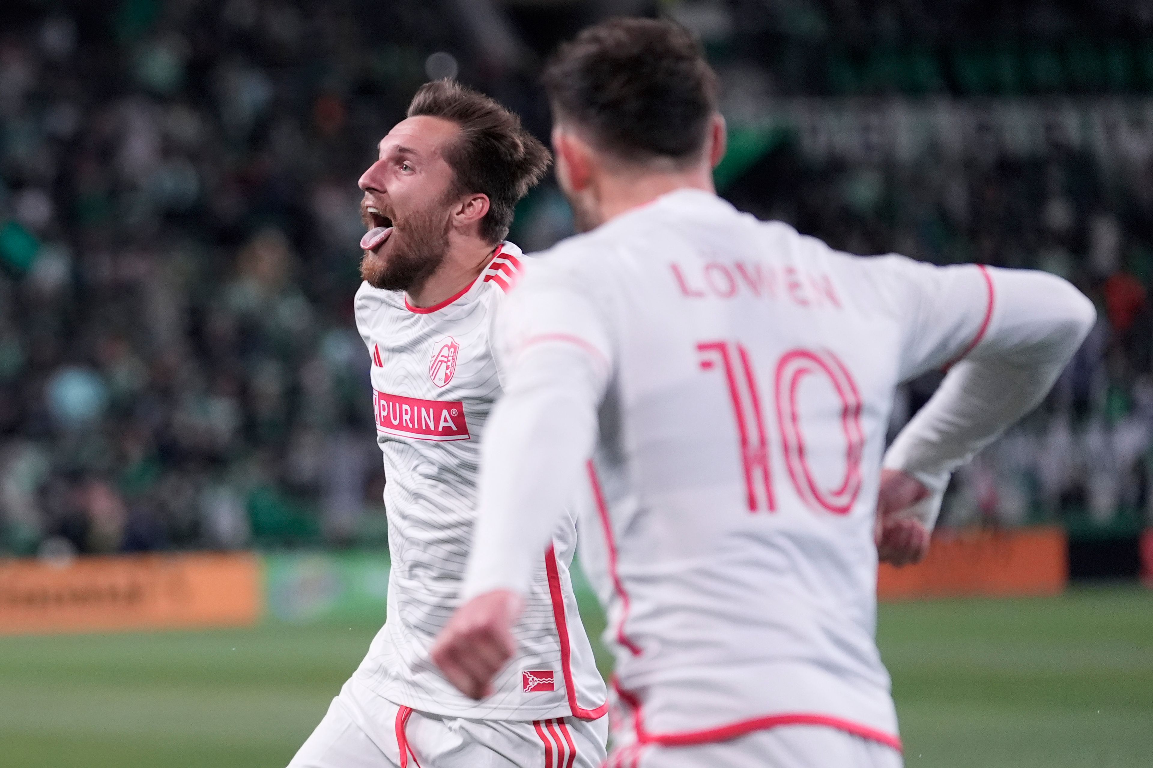 St. Louis City midfielder Indiana Vassilev, left, celebrates after teammate midfielder Eduard Lowen (10) scored against Austin FC during the second half of an MLS soccer match in Austin, Texas, Saturday, March 9, 2024. (AP Photo/Eric Gay)
