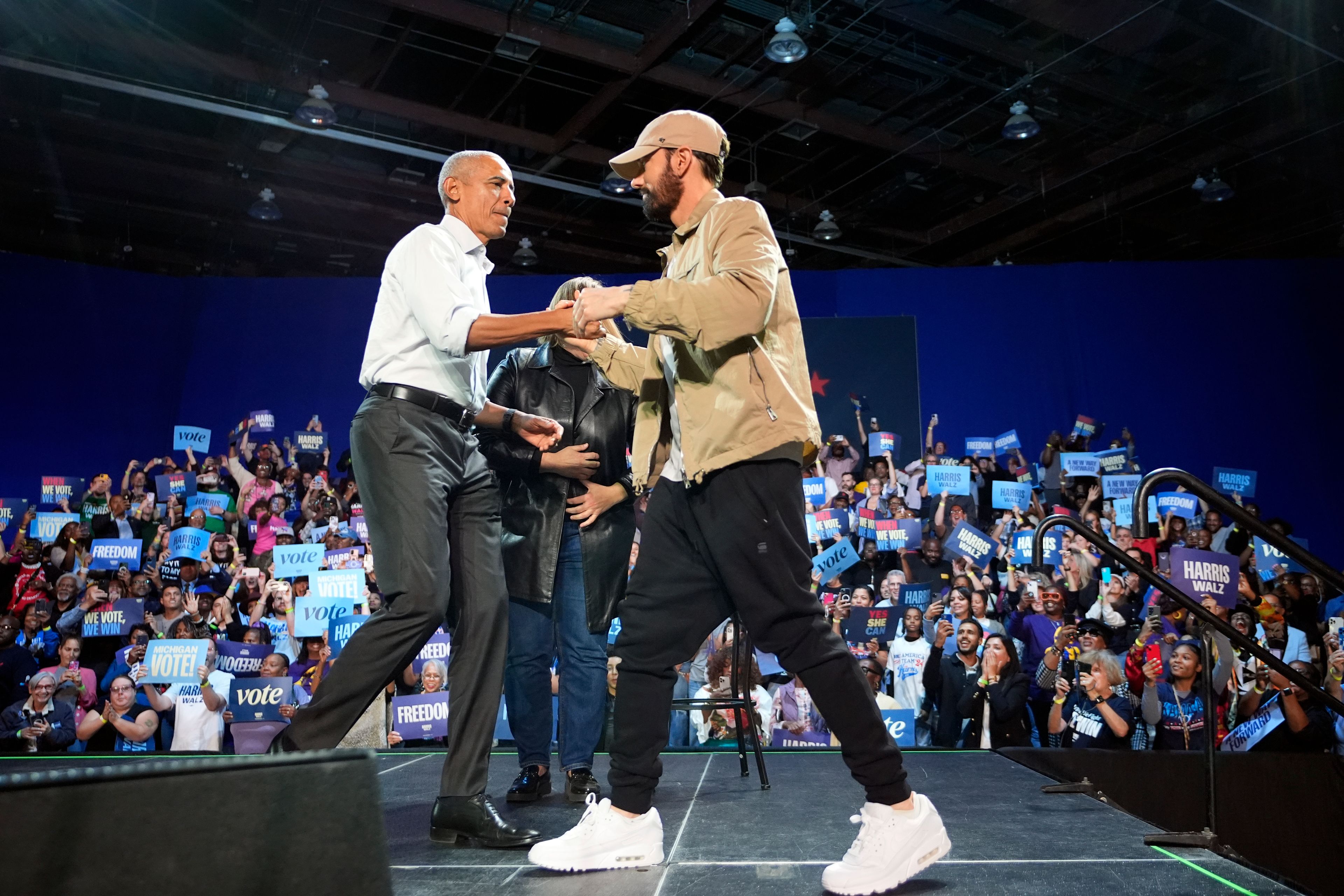 Rapper Eminem, right, greets former President Barack Obama, left, on stage at a campaign rally supporting Democratic presidential nominee Vice President Kamala Harris, Tuesday, Oct. 22, 2024, in Detroit. (AP Photo/Paul Sancya)