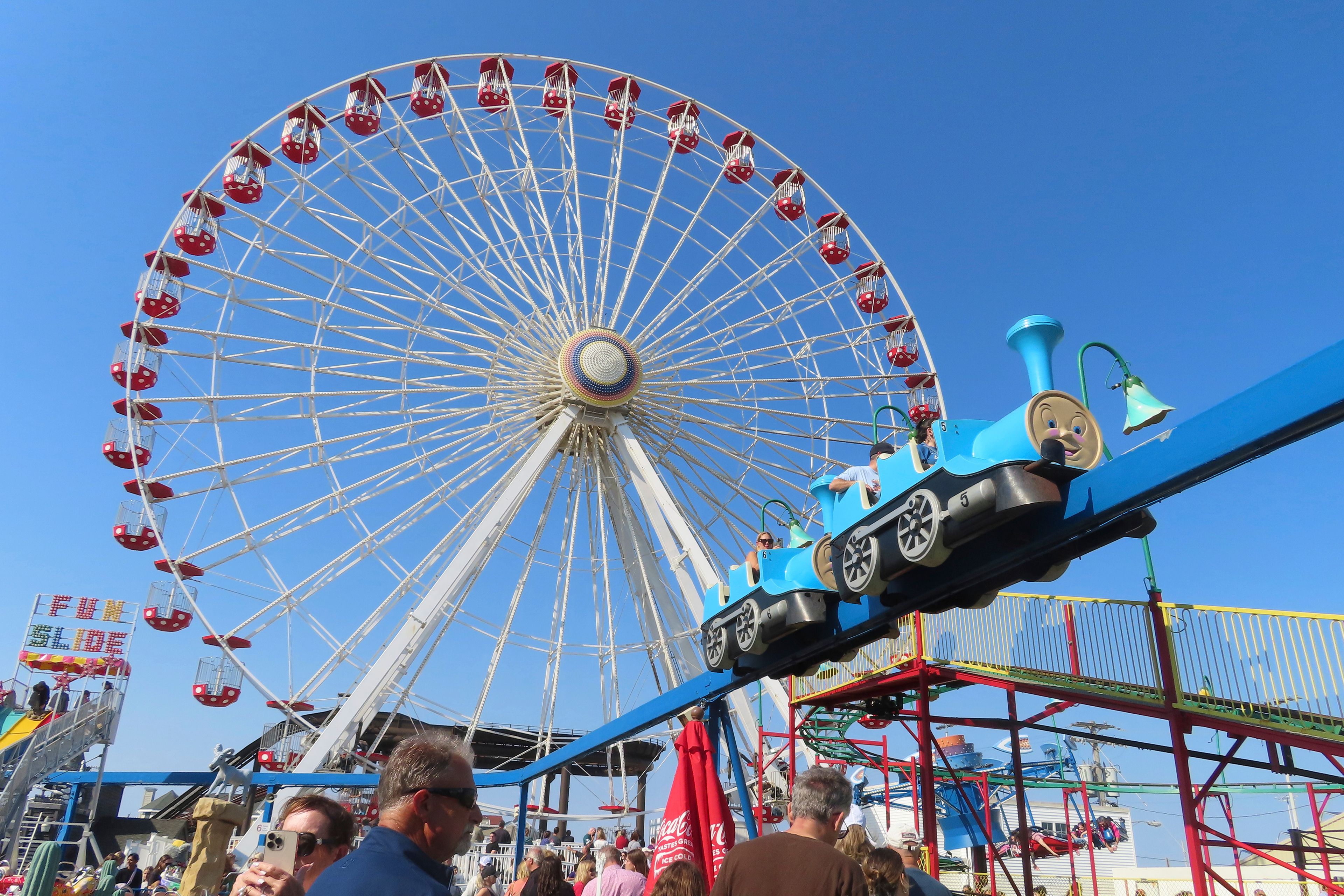 People wait in line to board rides at Gillian's Wonderland, the popular amusement park on the boardwalk in Ocean City, N.J., during its final day of operation before shutting down for good, Sunday, Oct. 13, 2024. (AP Photo/Wayne Parry)