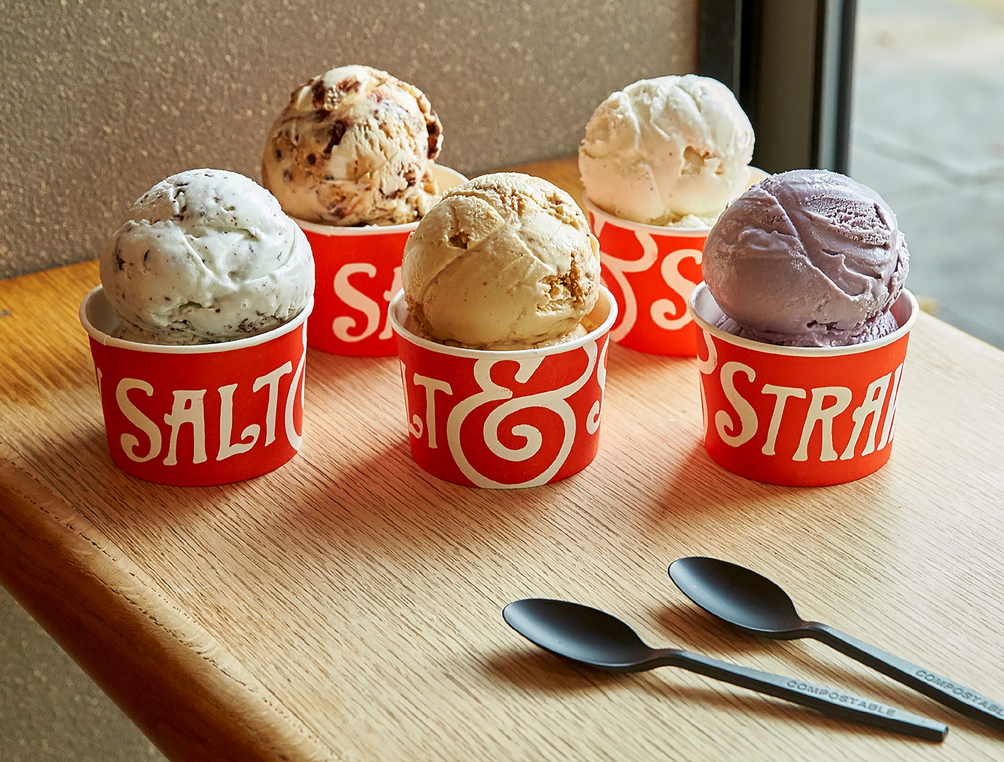 This image provided by Salt & Straw shows a variety of the West Coast ice creamery's unique flavors. The company offers interesting combos like Pistachio with Saffron, and Hibiscus and Coconut. Others sound like a warm hug in gelid form: Jasmine Milk Tea laced with chocolate-coated almond slivers, or Rhubarb Crumble with Toasted Anise. (Salt & Straw via AP)