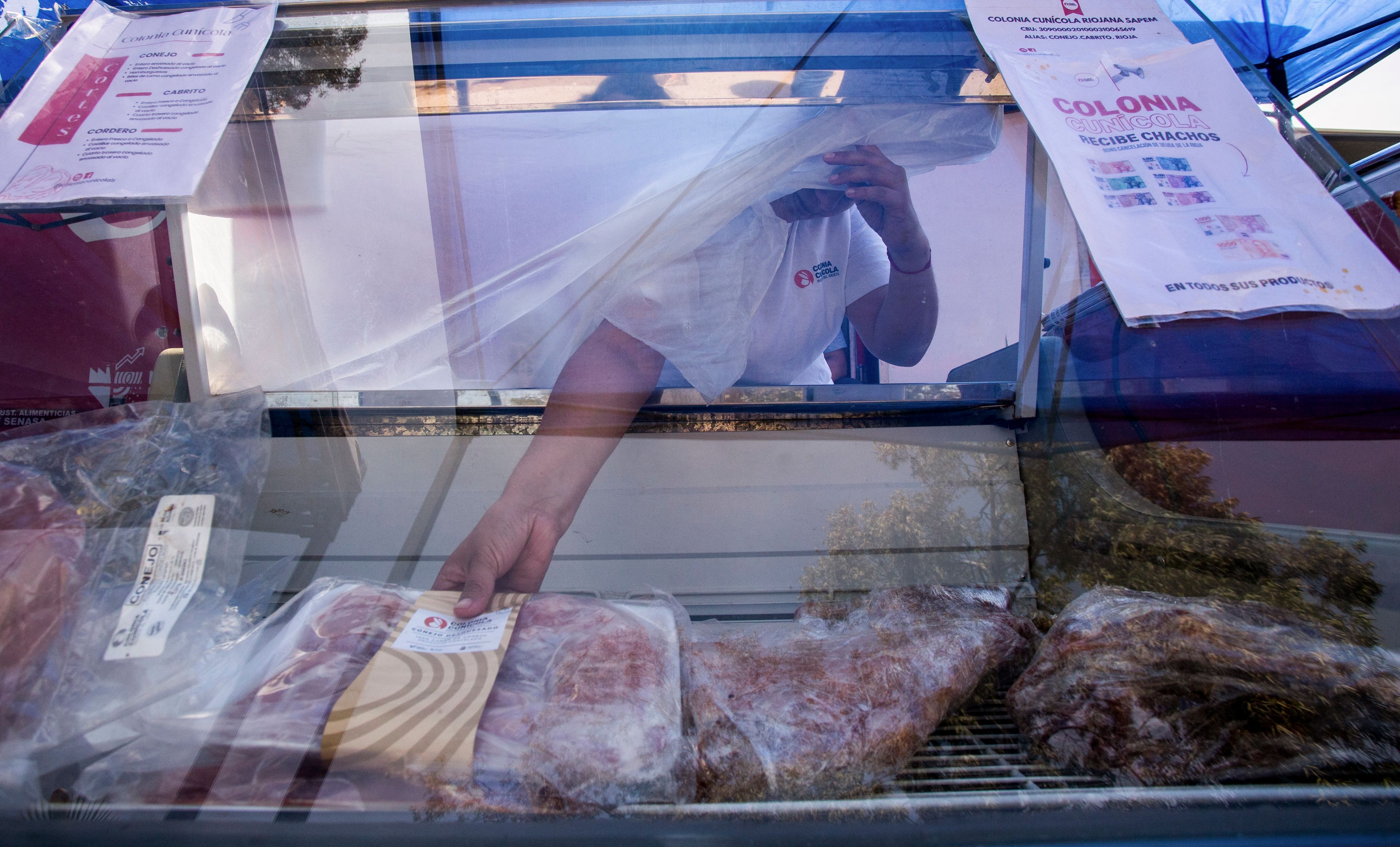 A butcher works at his stall that accepts "chacos" as payment in La Rioja, Argentina, Saturday, Sept. 21, 2024. In response to slashed federal budgets to provinces, La Rioja is printing a new emergency tender called "chachos" to pay state workers and spur the economy. (AP Photo/Natalia Diaz)