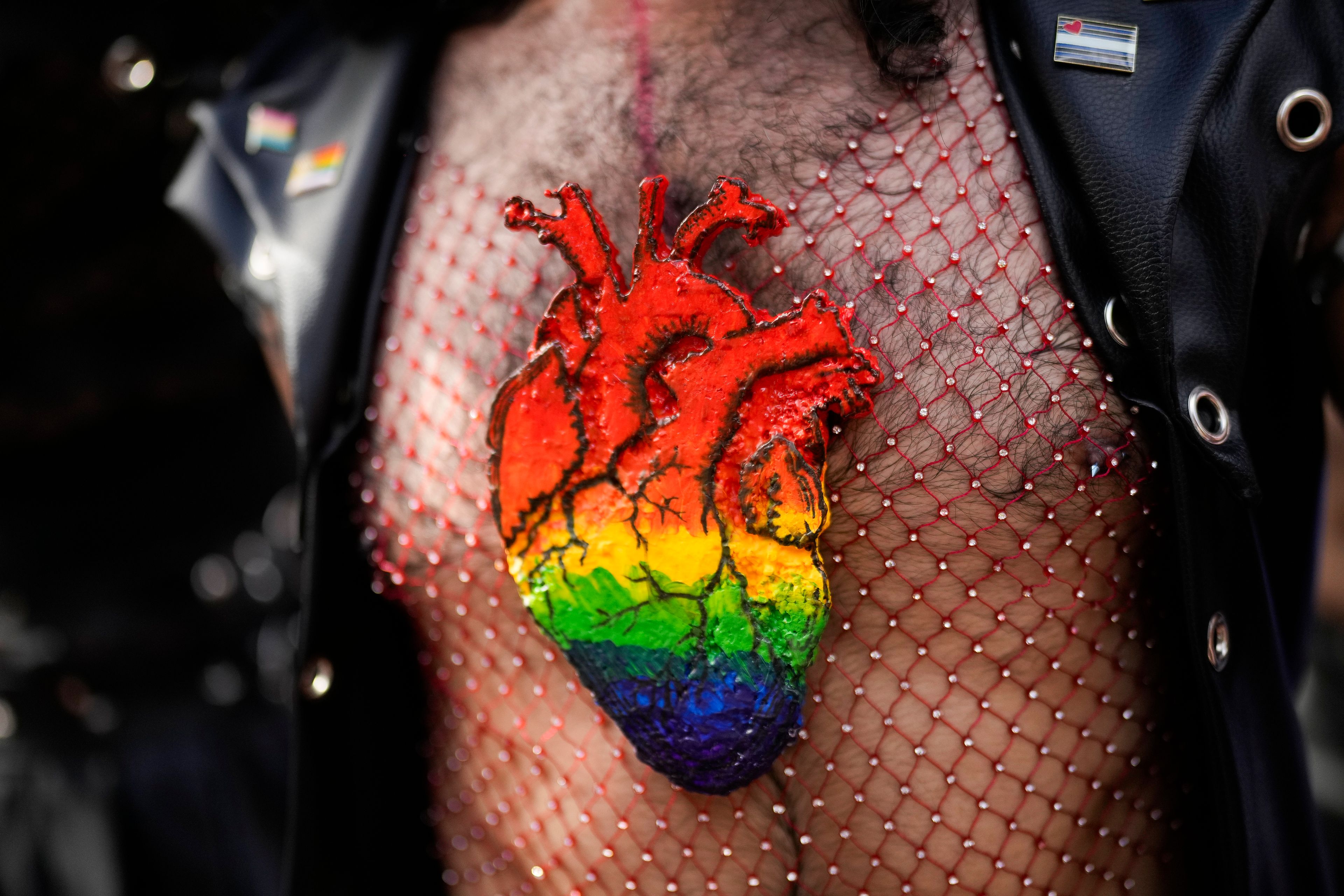 A reveler, wearing a rainbow-colored heart shape on his chest, takes part in a Pride parade marking the culmination of LGBTQ+ Pride month in Panama City, Saturday, June 29, 2024. (AP Photo/Matias Delacroix)