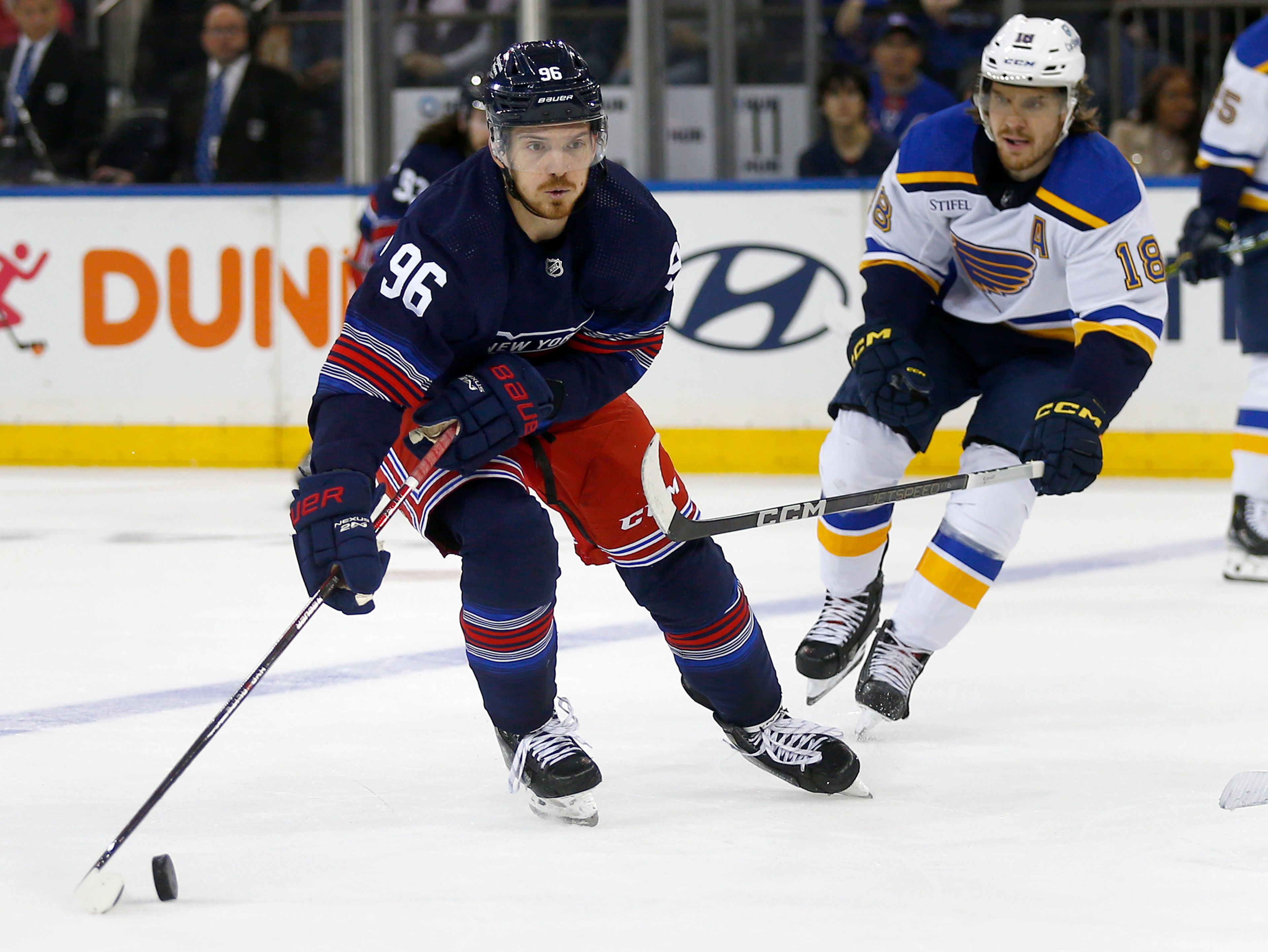 New York Rangers center Jack Roslovic (96) controls the puck while defended by St. Louis Blues center Robert Thomas (18) during the first period of an NHL hockey game Saturday, March 9, 2024, in New York. (AP Photo/John Munson)