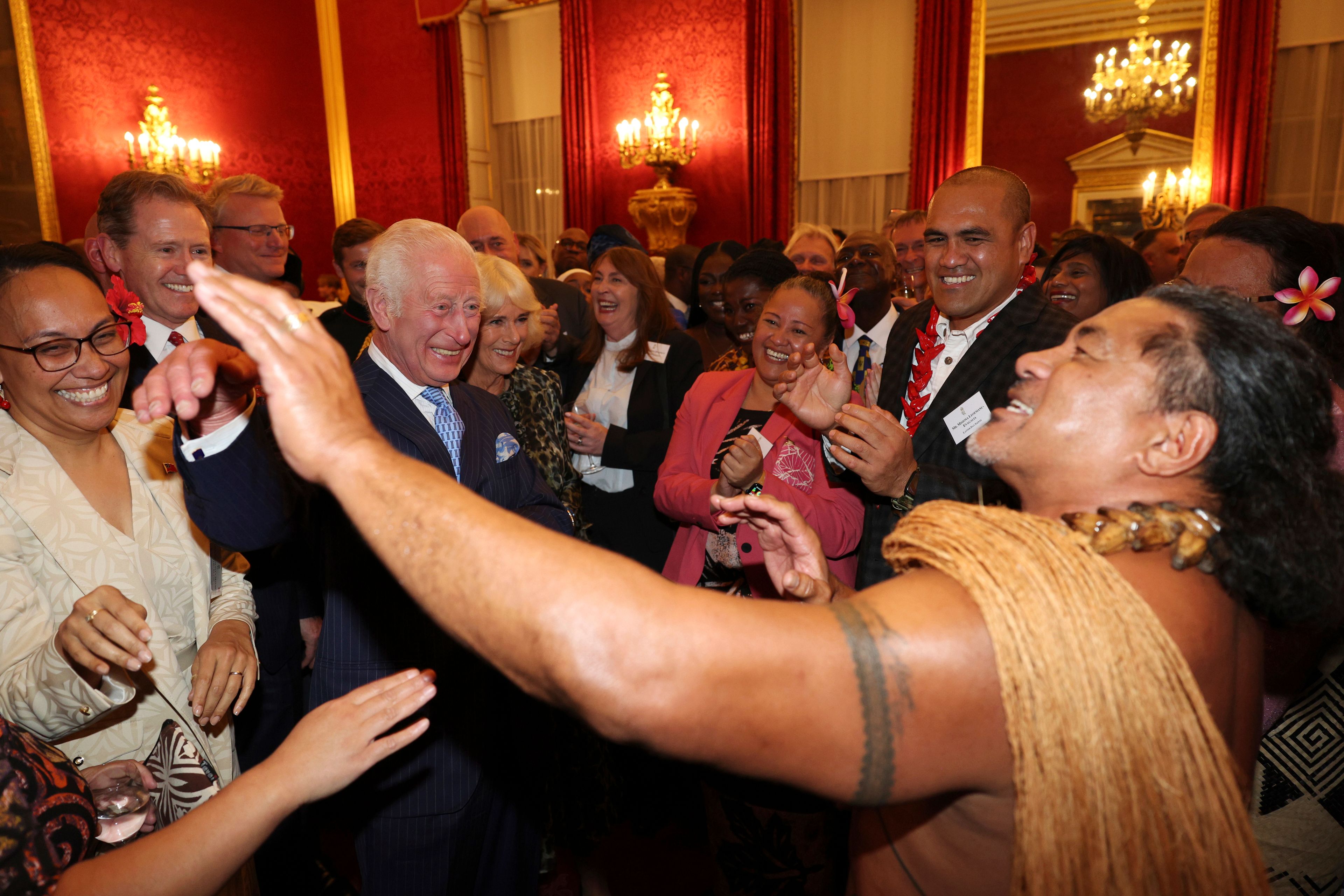 FILE - Britain's King Charles III, second from left, and Queen Camilla, third from left, smile as former Samoan rugby player Freddie Tuilagi dances during a reception to celebrate the Commonwealth Diaspora of the United Kingdom, ahead of the Commonwealth Heads of Government Meeting in Samoa, at St. James's Palace, London, on Oct. 2, 2024. (Adrian Dennis, Pool Photo via AP, File)