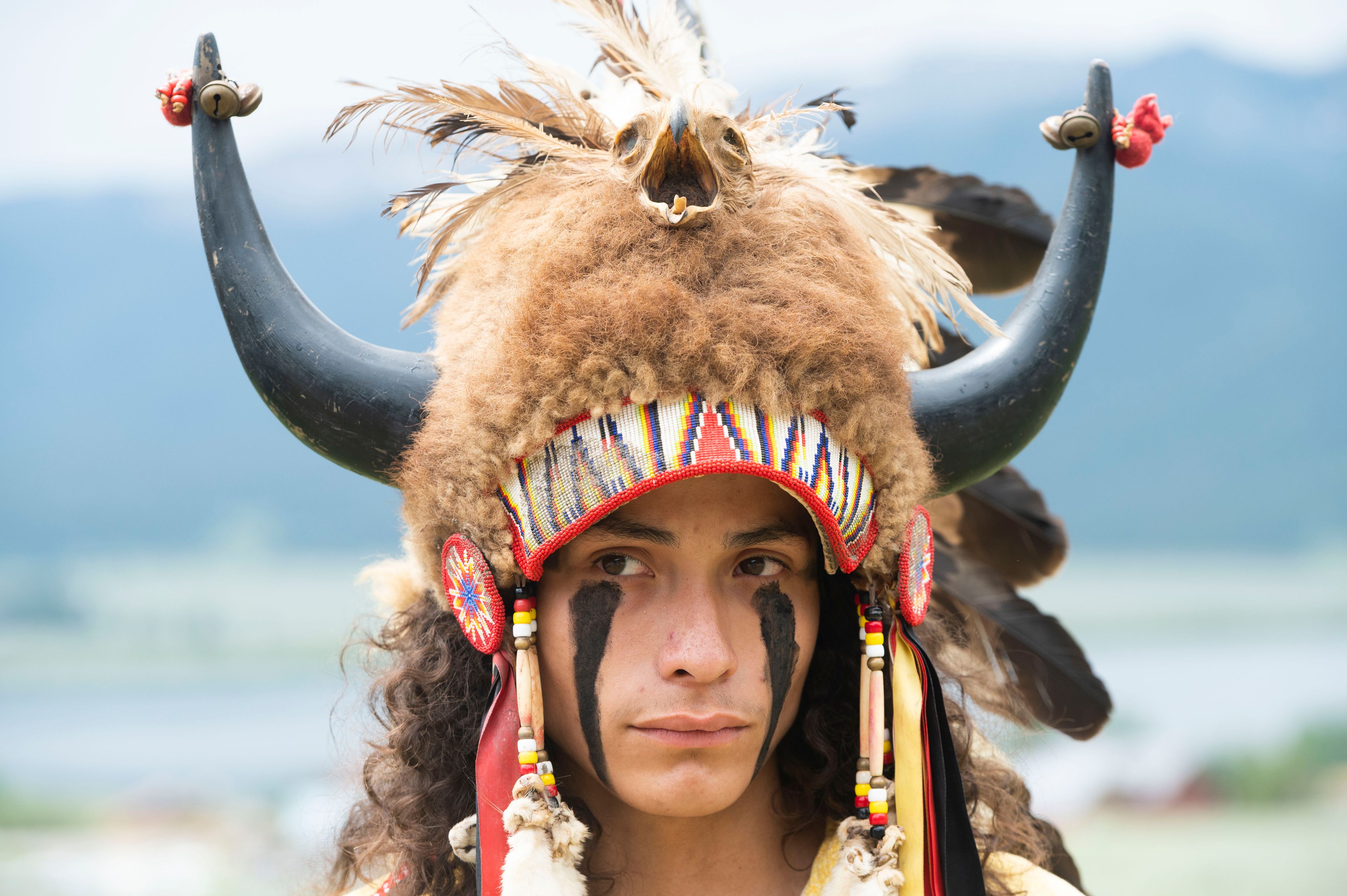Ota Bluehorse, a member of the Spirit Lake Tribe, wears a headdress adorned with bison horns during a naming ceremony for a white buffalo calf at the Buffalo Field Campaign headquarters in West Yellowstone, Mont., Wednesday, June 26, 2024. The reported birth of a white buffalo calf in Yellowstone National Park fulfills a Lakota prophecy that portends better times. (AP Photo/Sam Wilson)
